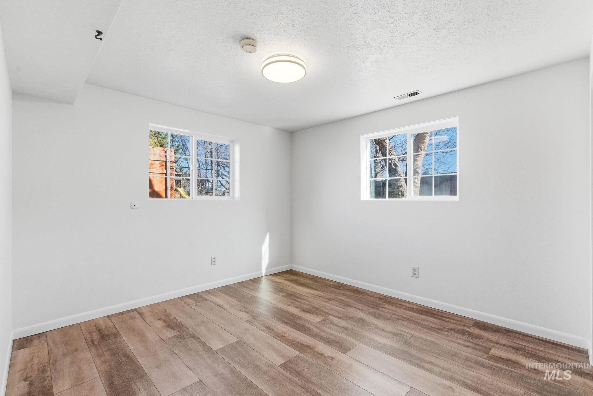 Spare room featuring light wood-style flooring and a textured ceiling