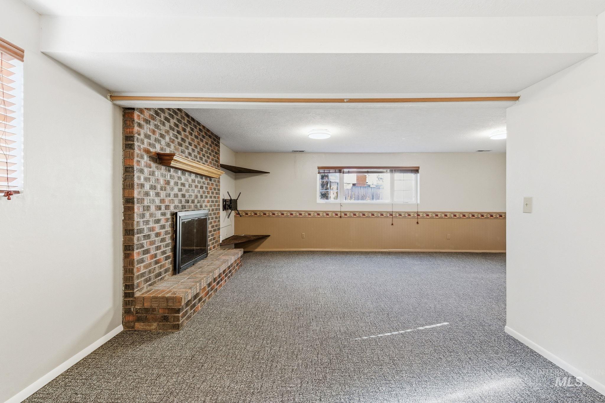 Unfurnished living room featuring carpet flooring and a fireplace