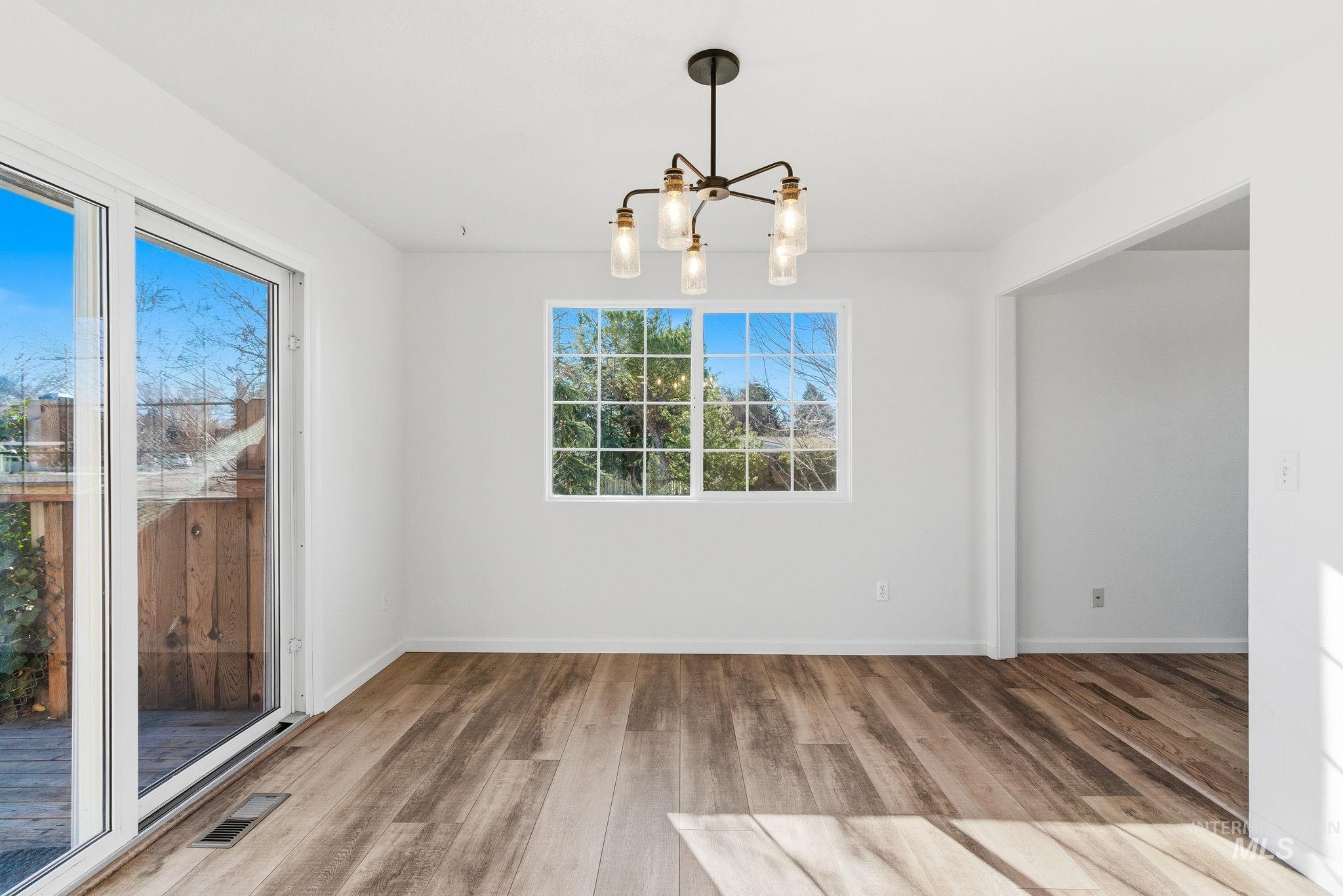 Unfurnished dining area featuring a chandelier and light wood finished floors