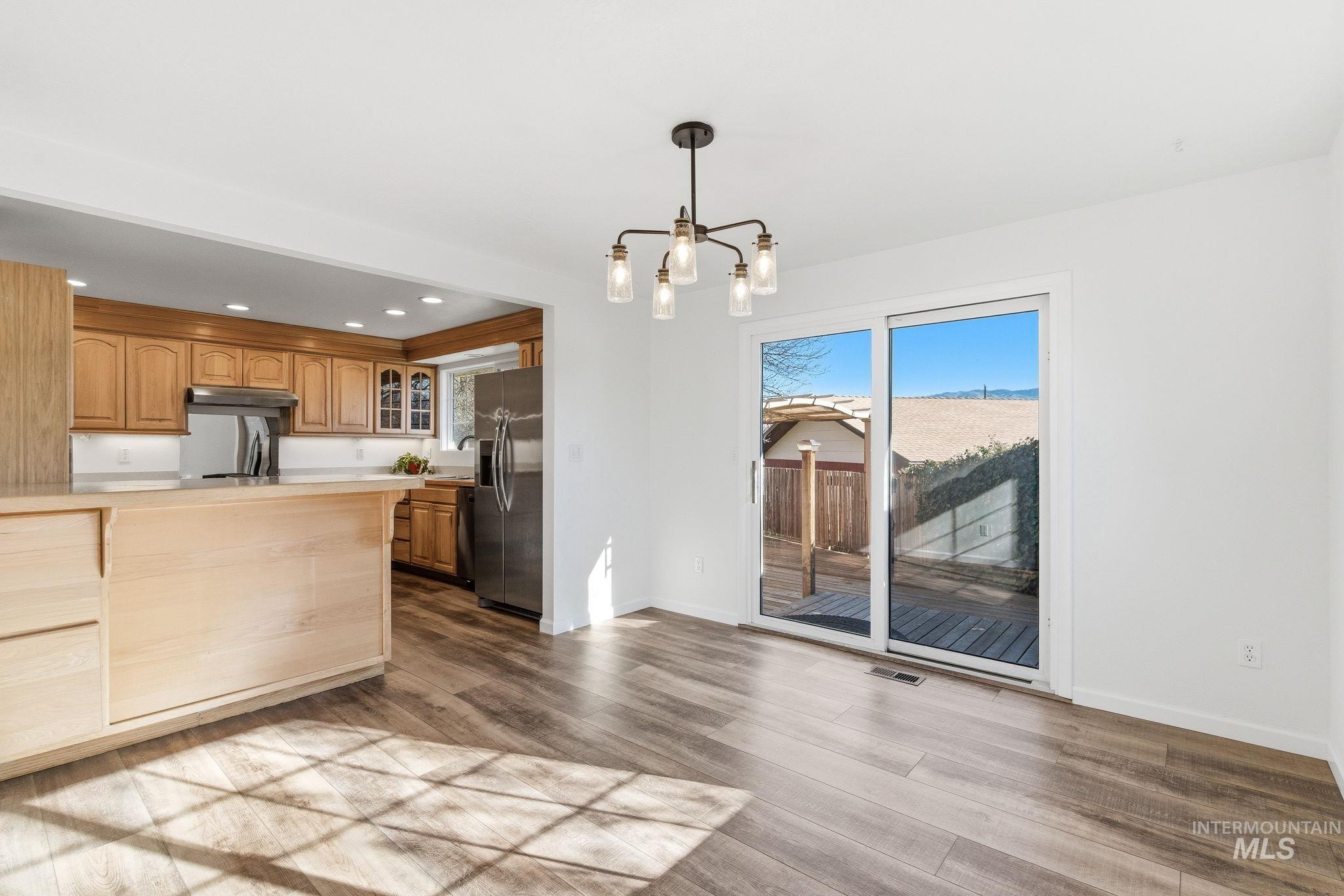 Kitchen with glass fronted cabinets, plenty of natural light, light countertops, and stainless steel fridge with ice dispenser
