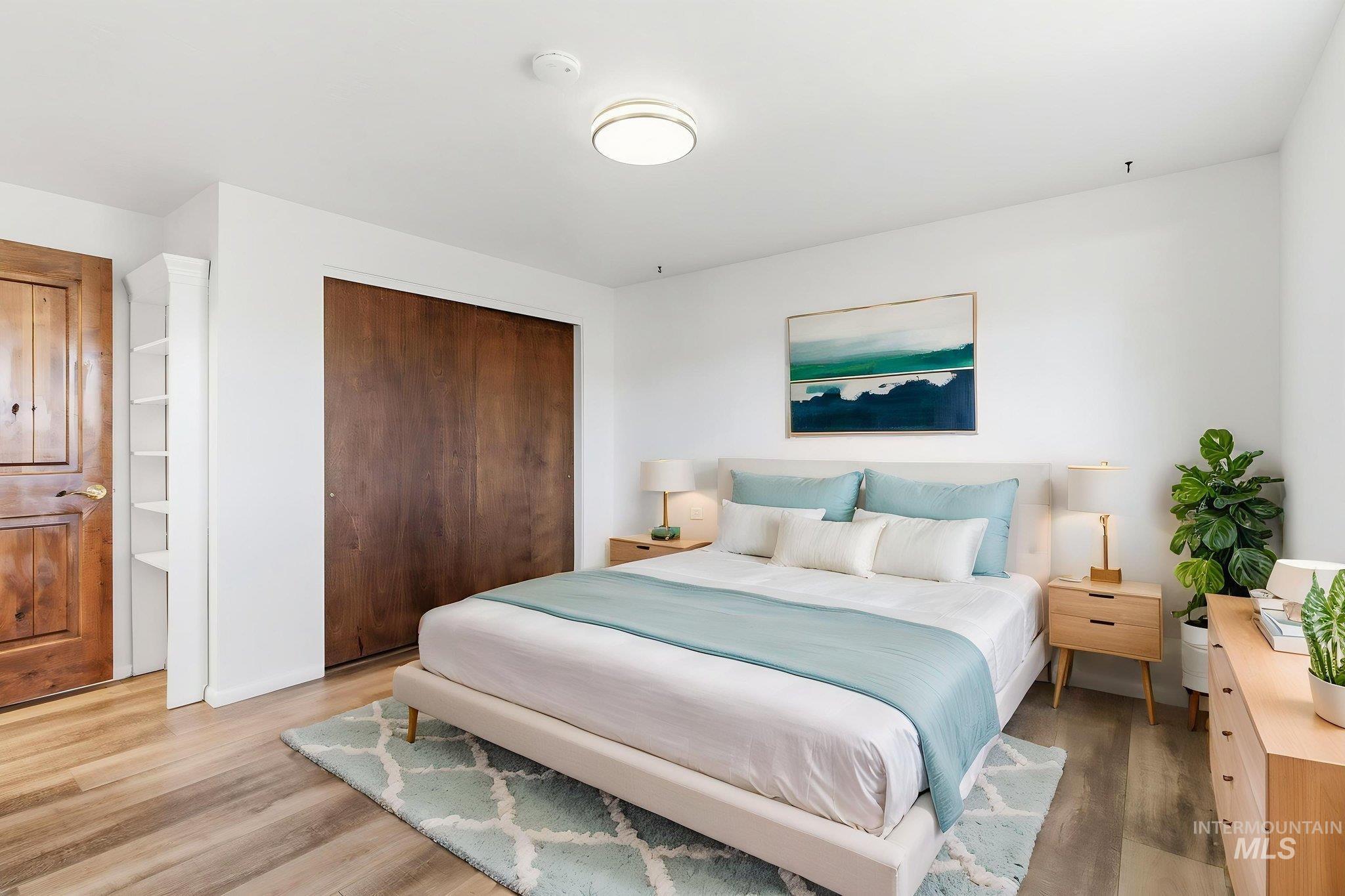 Bedroom with light wood-style flooring and a closet