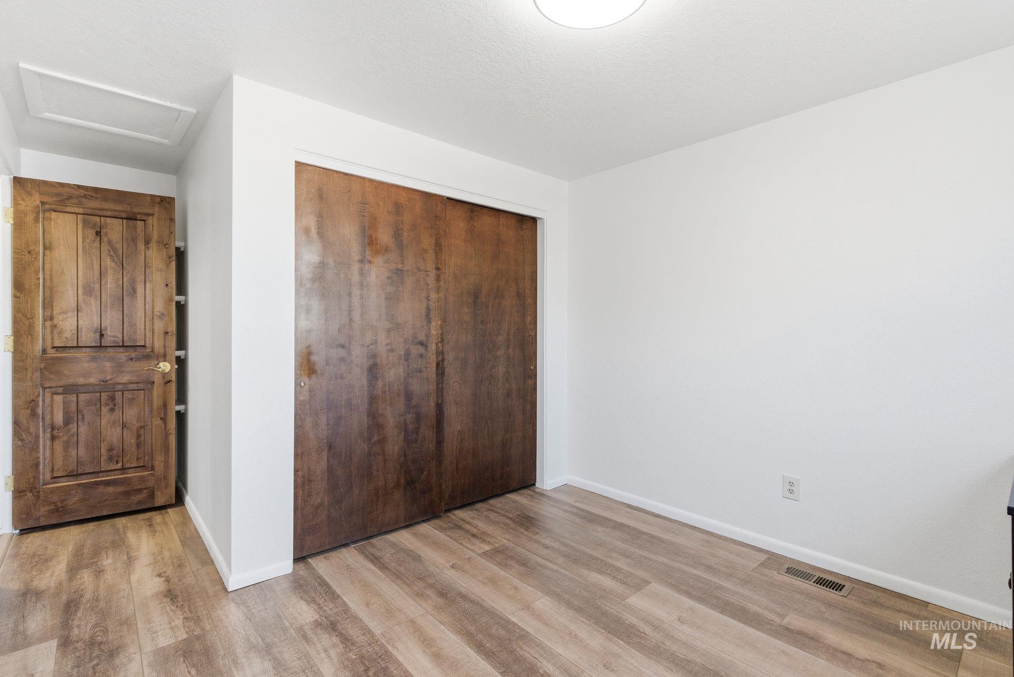 Unfurnished bedroom featuring a closet and light wood-style floors