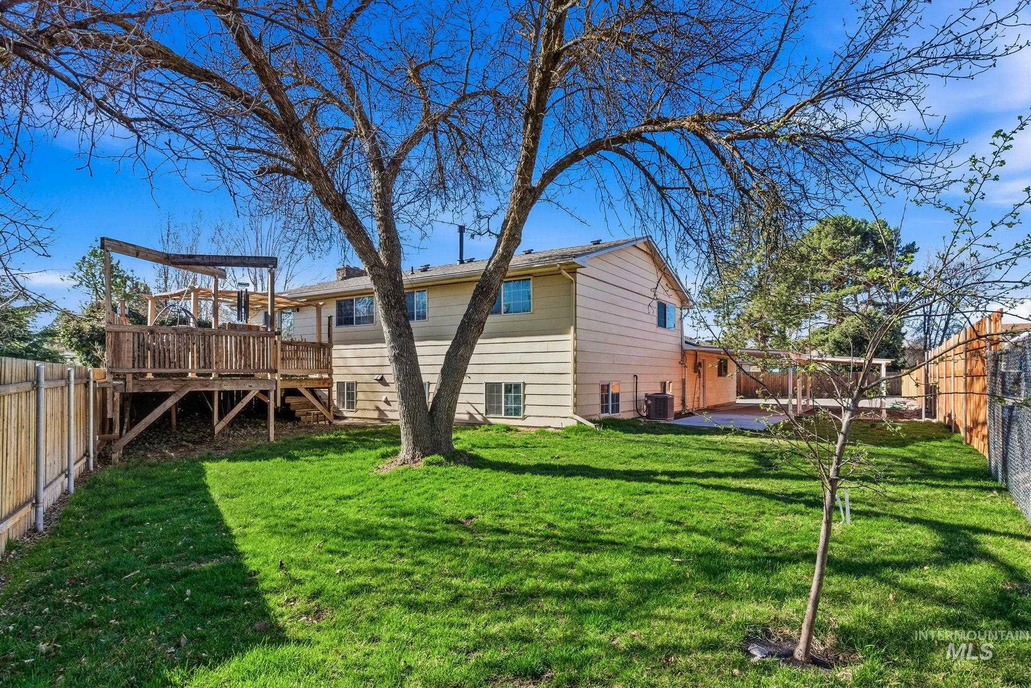 Back of house with a fenced backyard and a deck