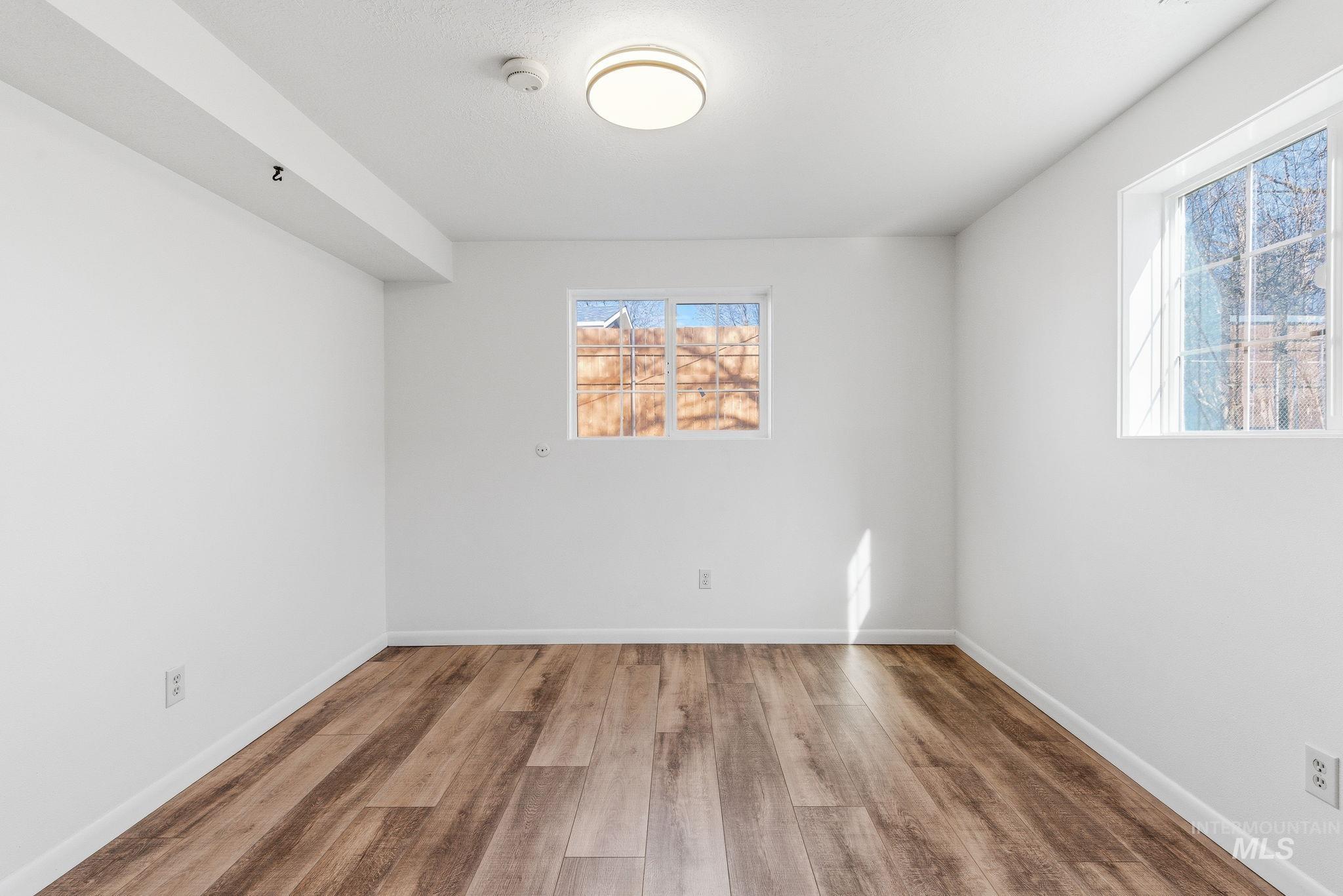 Spare room featuring wood finished floors and baseboards