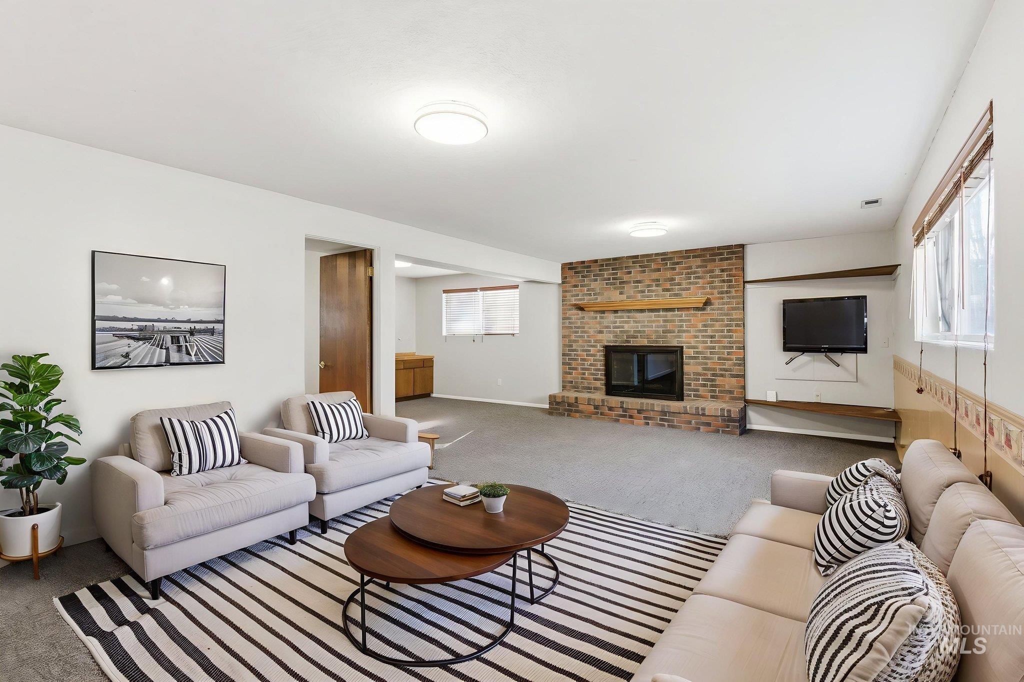 Living area with carpet floors and a brick fireplace