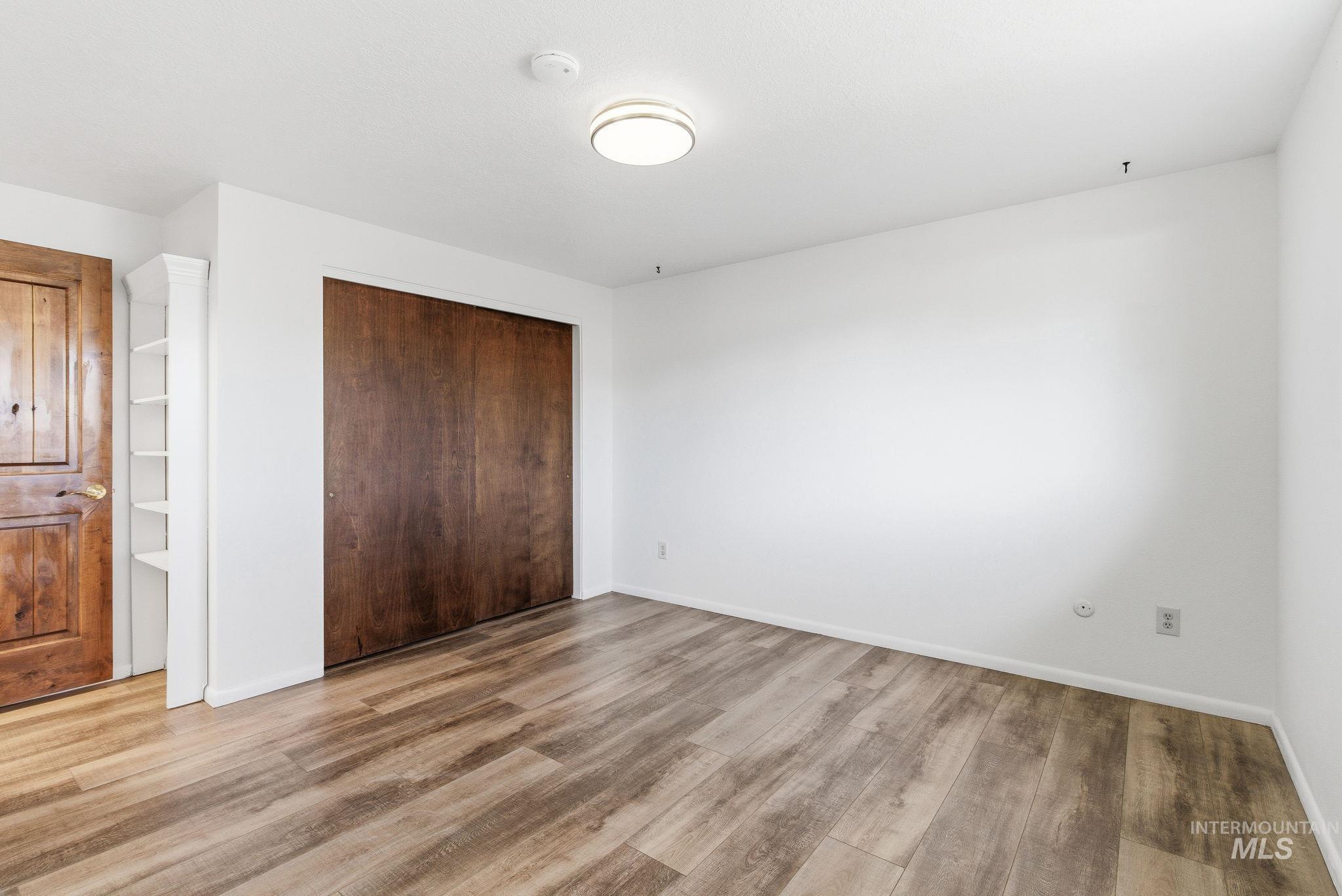 Unfurnished bedroom with light wood-type flooring and a closet