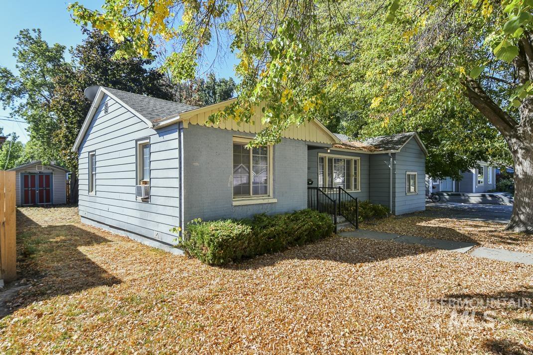 View of home's exterior with a storage shed, brick siding, and roof with shingles