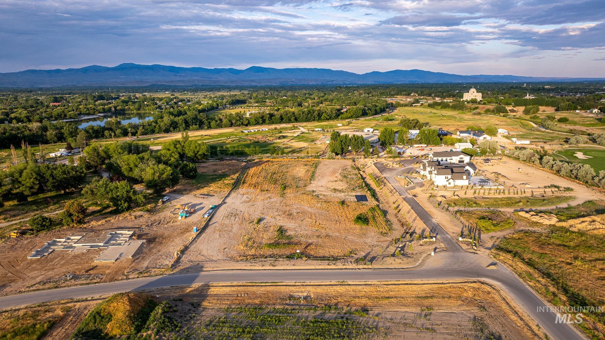 Aerial view of property and surrounding area featuring a mountain backdrop