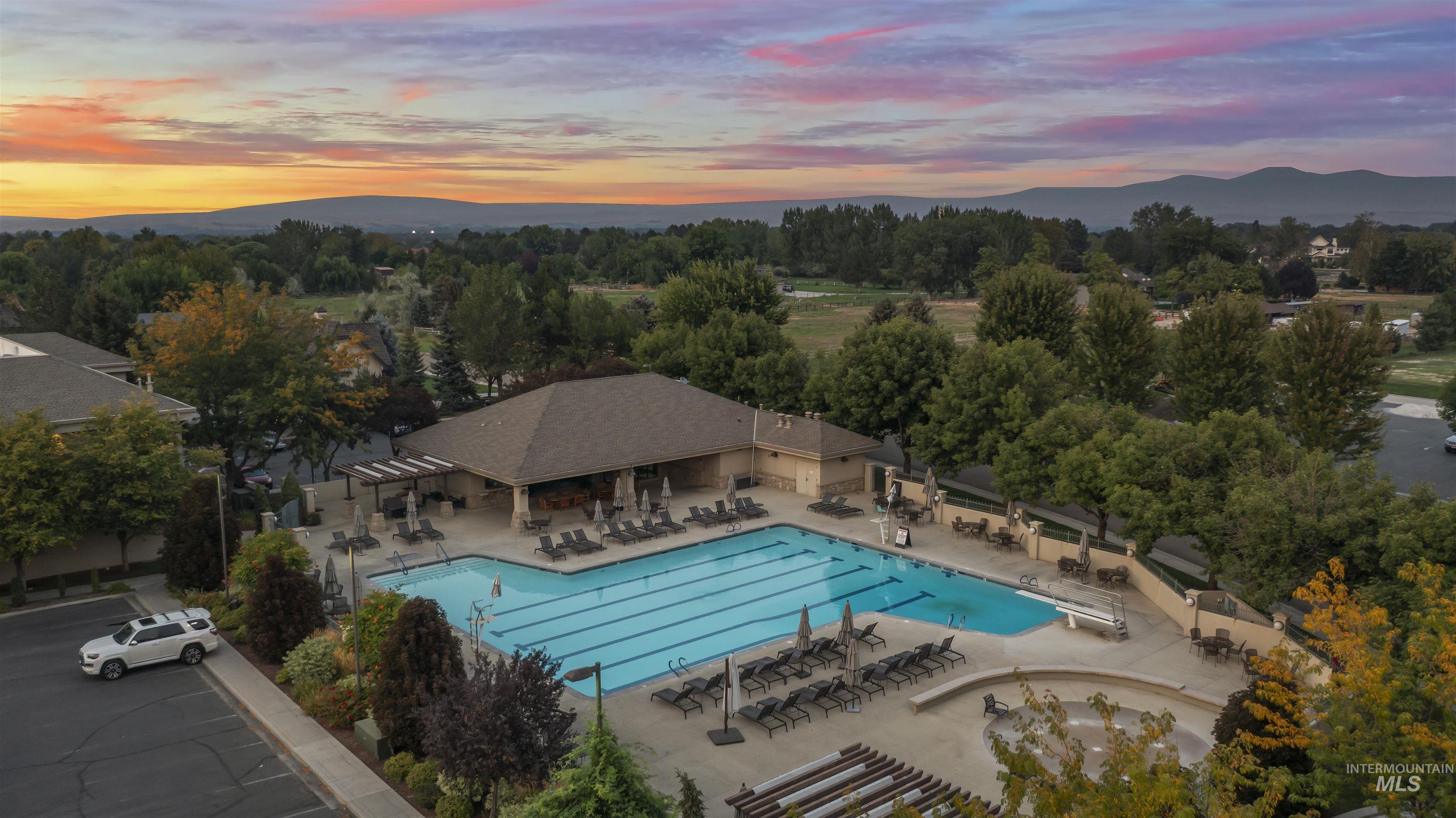 Community pool featuring a mountain view, a patio area, and view of wooded area