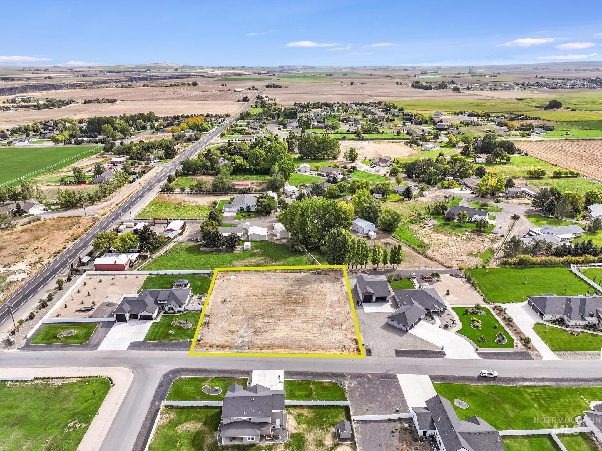 Overview of rural landscape featuring nearby suburban area and property parcel outlined