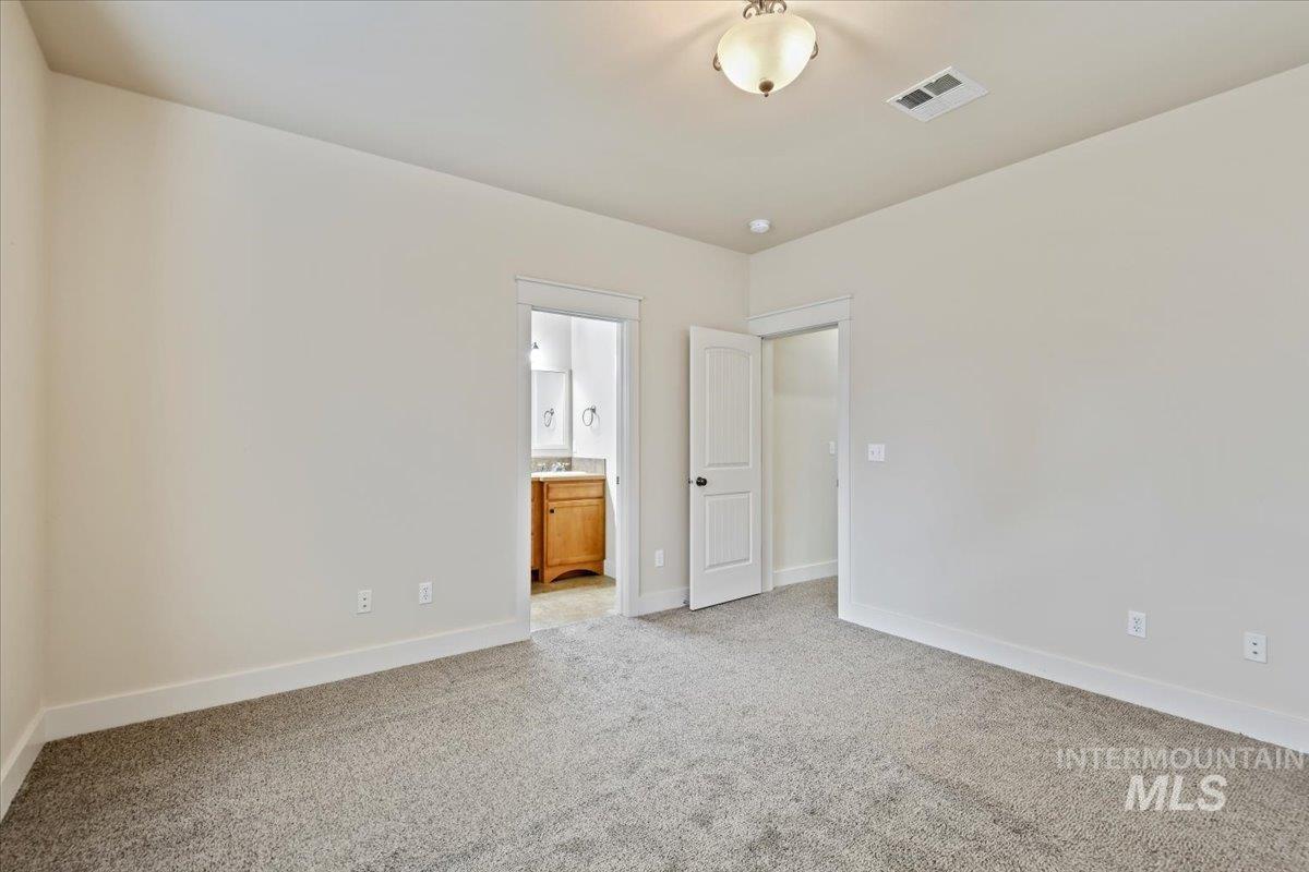 Unfurnished room with light colored carpet and baseboards
