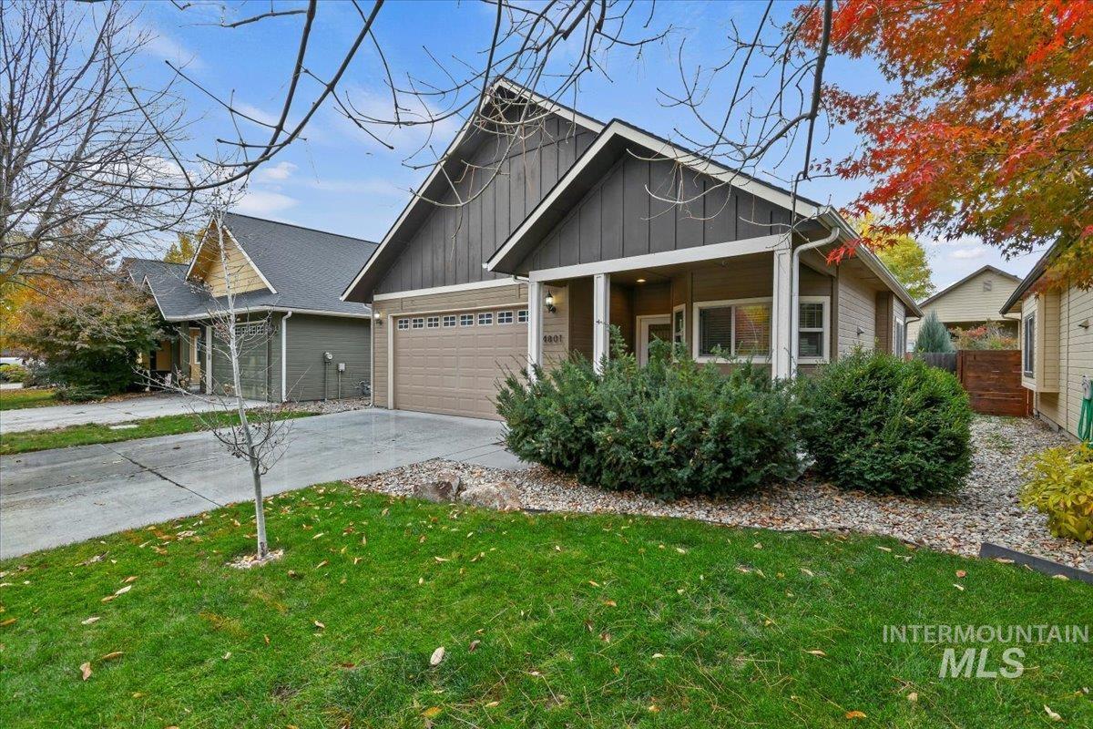 Craftsman-style home featuring concrete driveway, board and batten siding, a garage, and a front yard