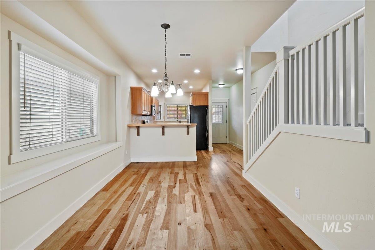 Kitchen featuring a breakfast bar, a chandelier, light countertops, recessed lighting, and decorative light fixtures