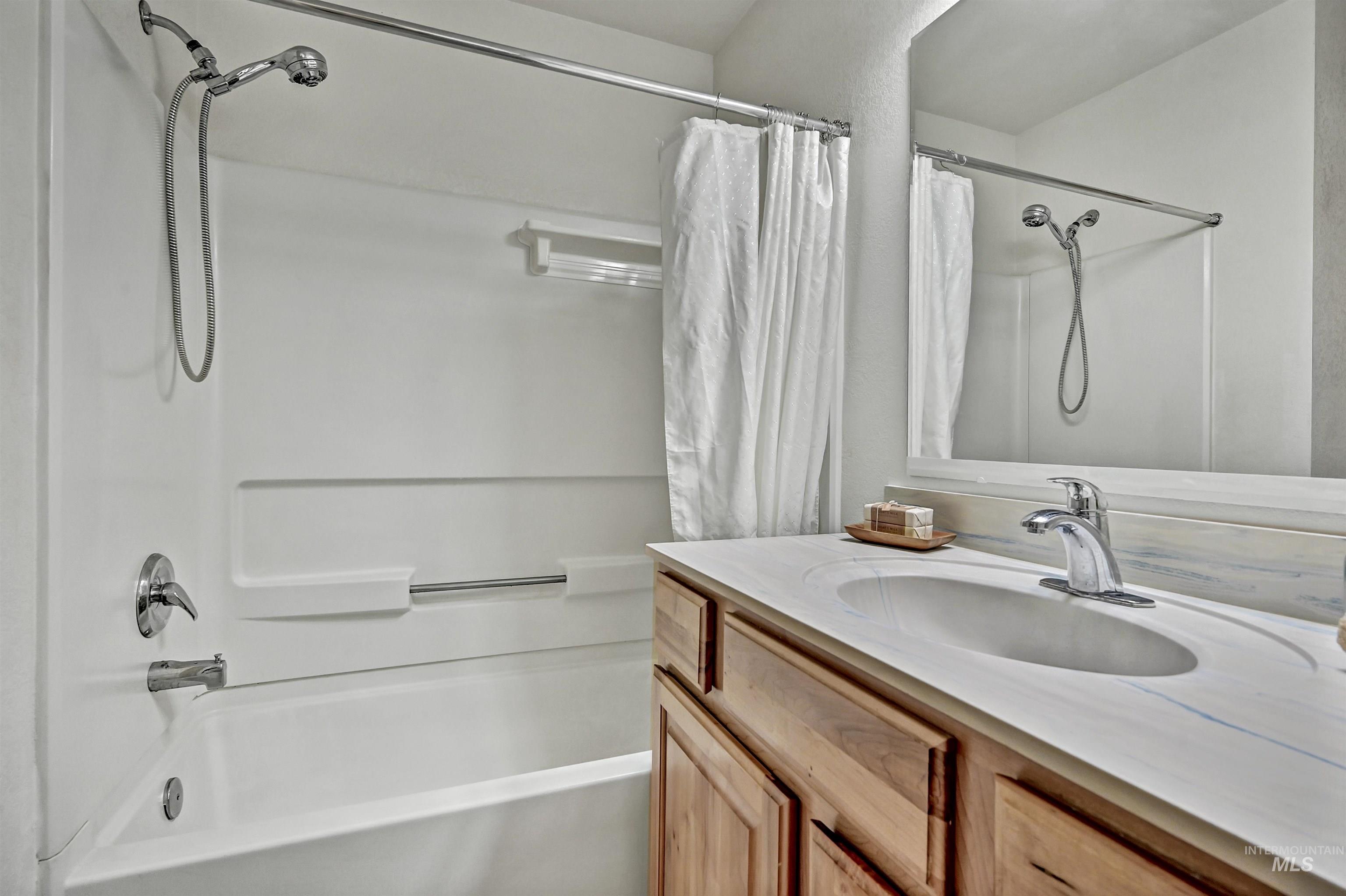 Full bathroom with shower / bathtub combination with curtain and vanity