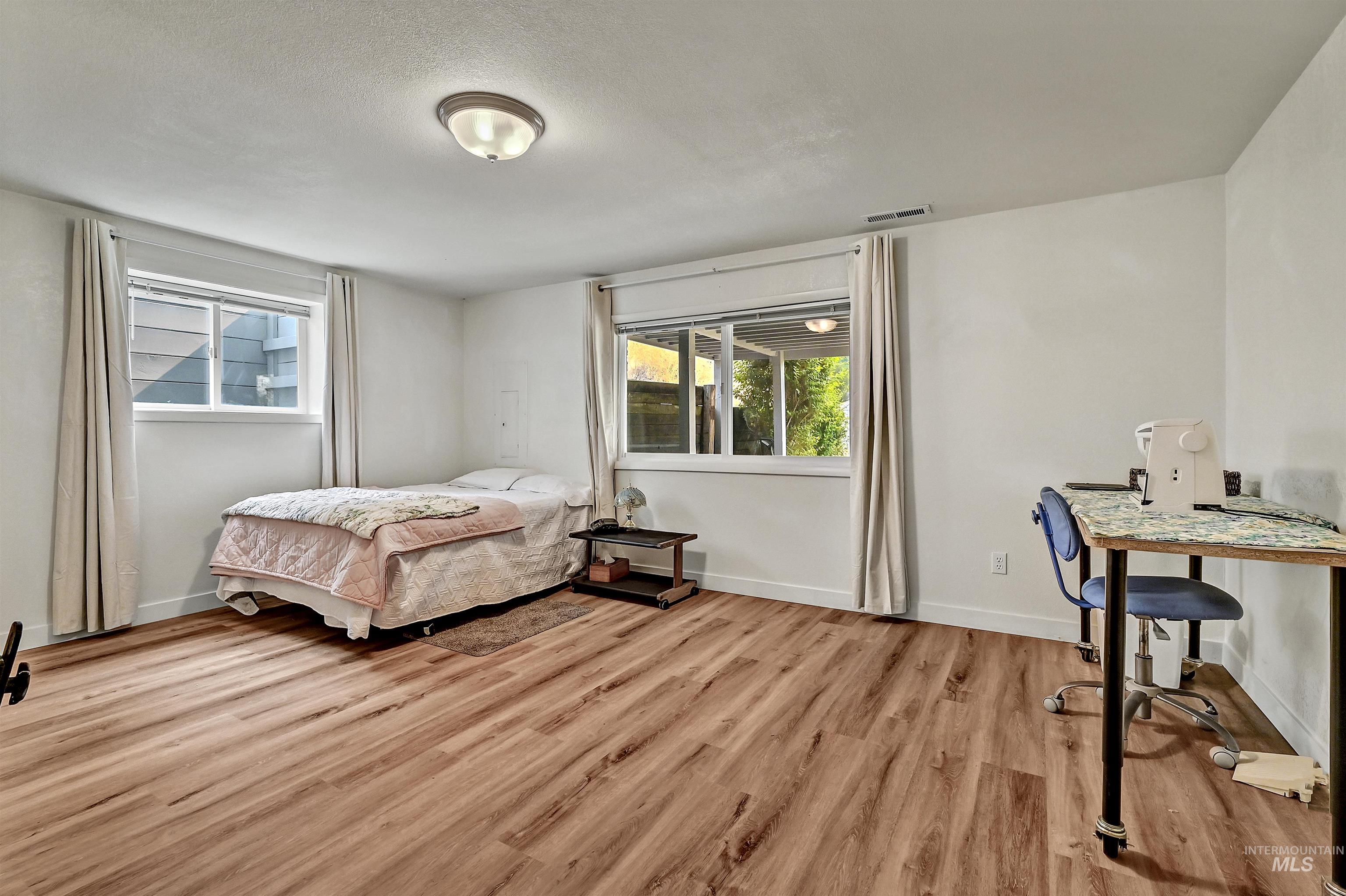 Bedroom with light wood-type flooring and baseboards