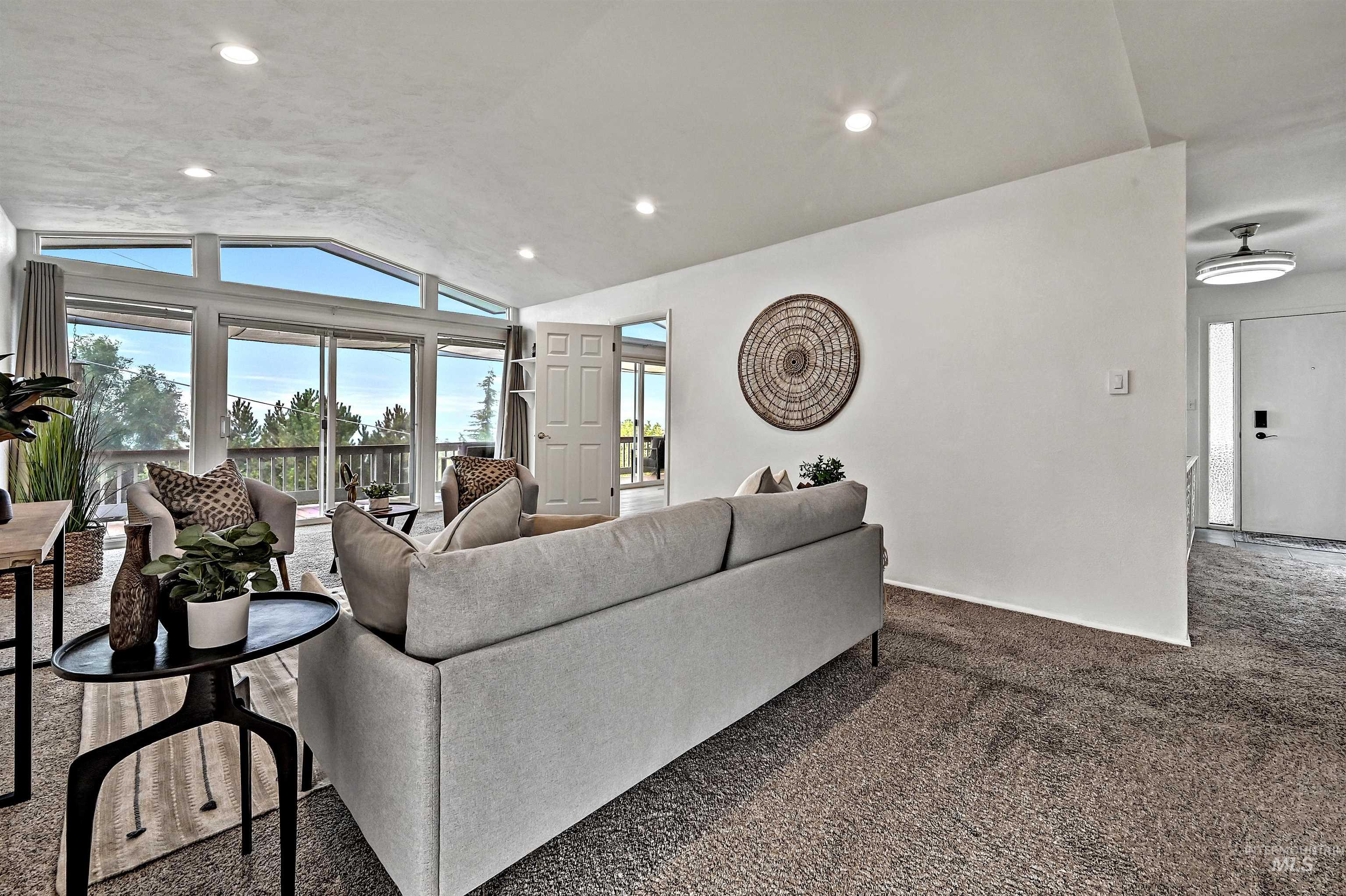 Living room with lofted ceiling, carpet, and recessed lighting