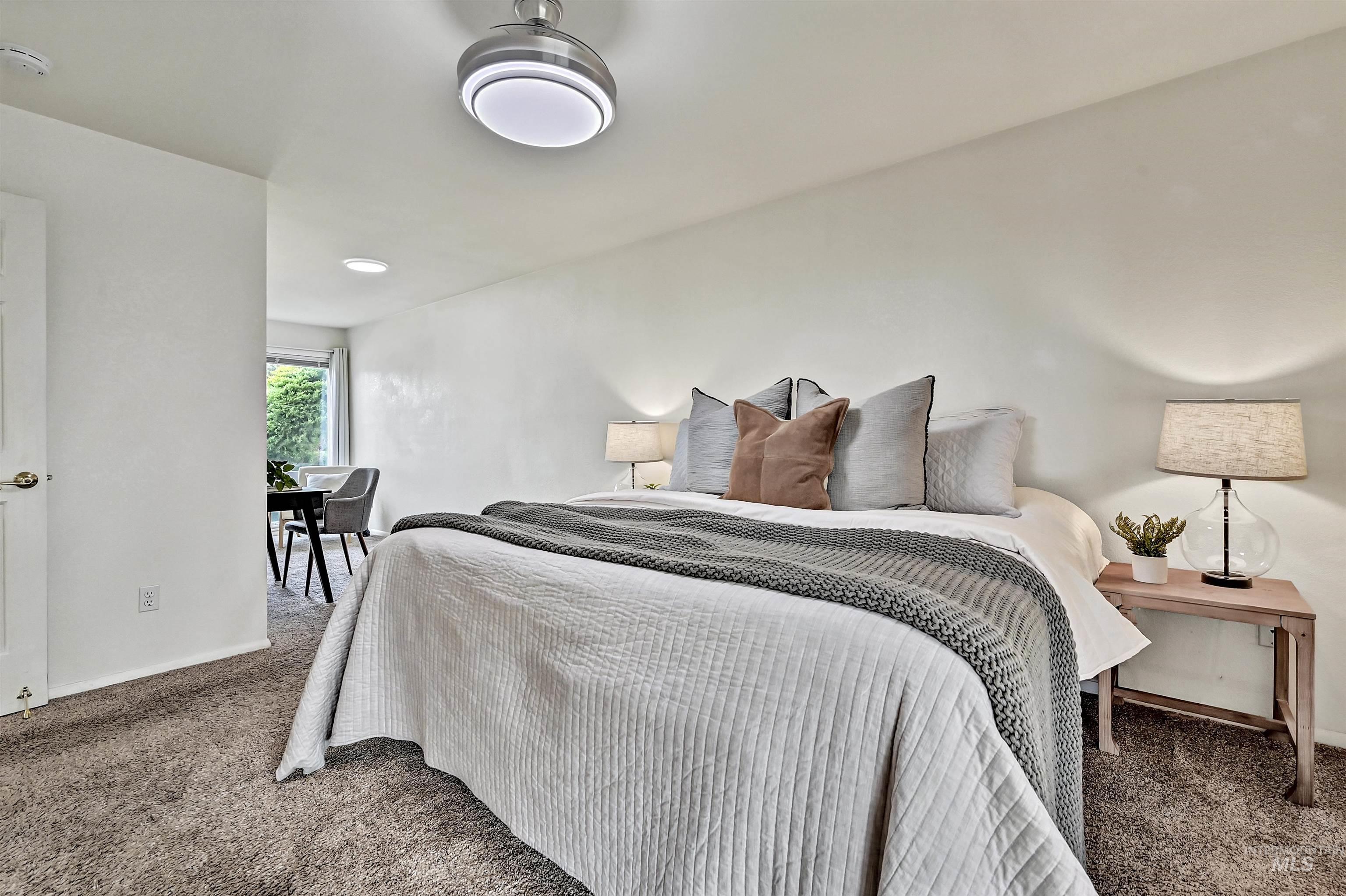 Bedroom with dark colored carpet and baseboards