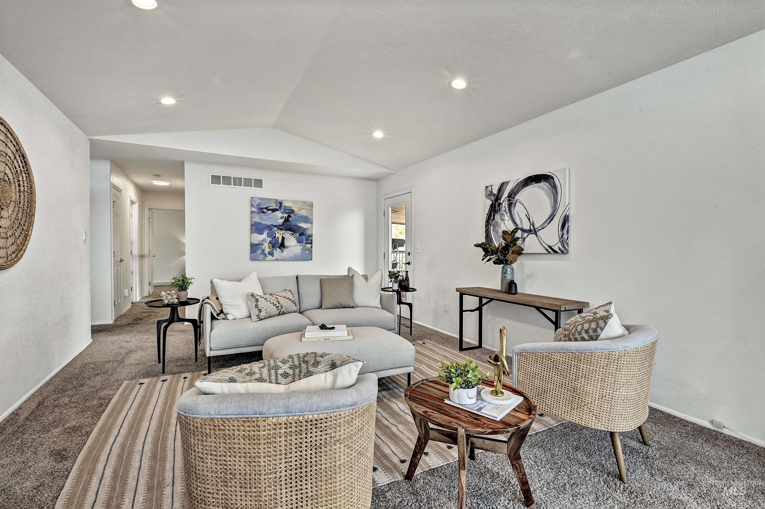 Carpeted living area with vaulted ceiling and recessed lighting
