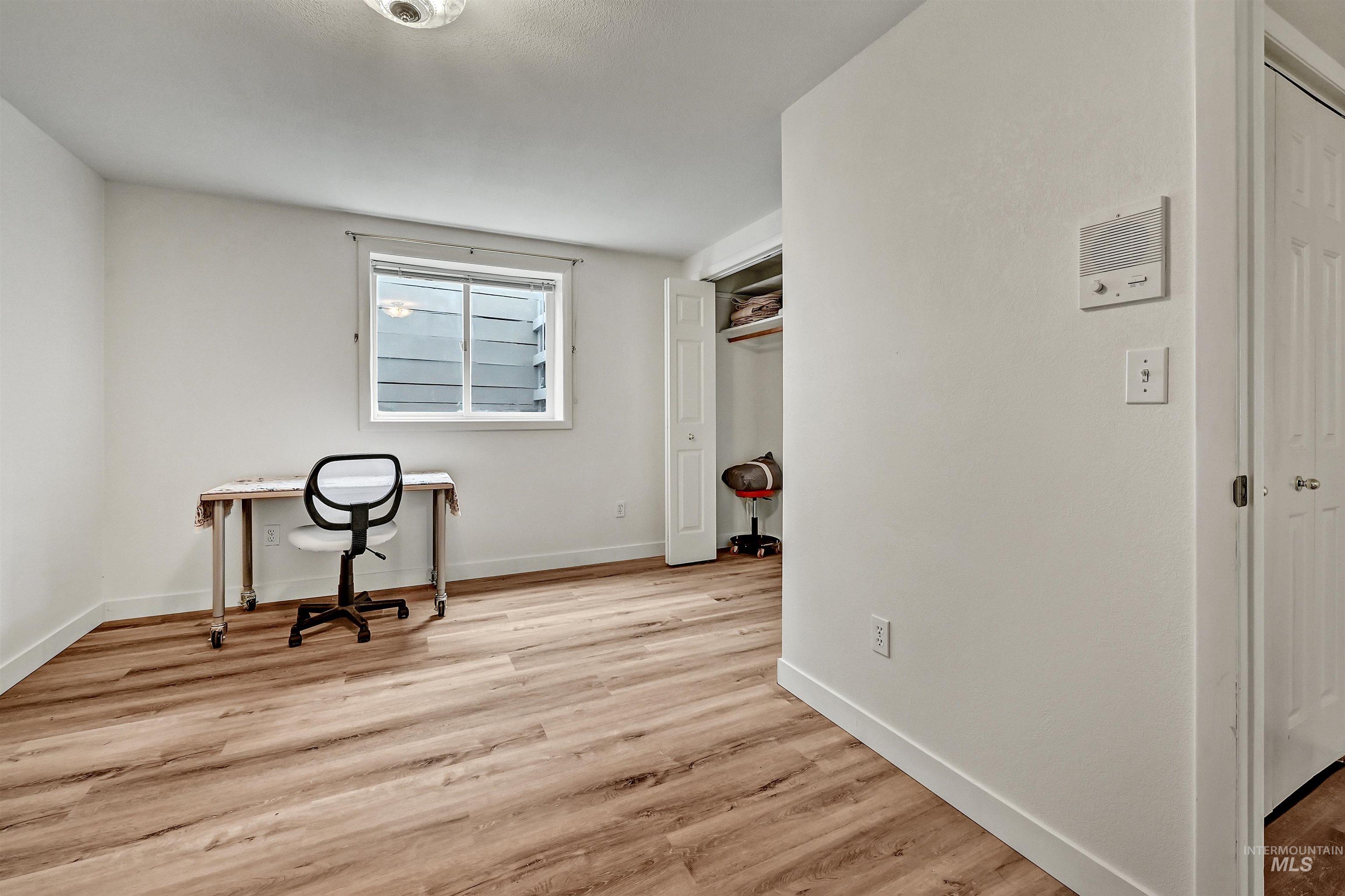 Unfurnished office with wood finished floors and baseboards