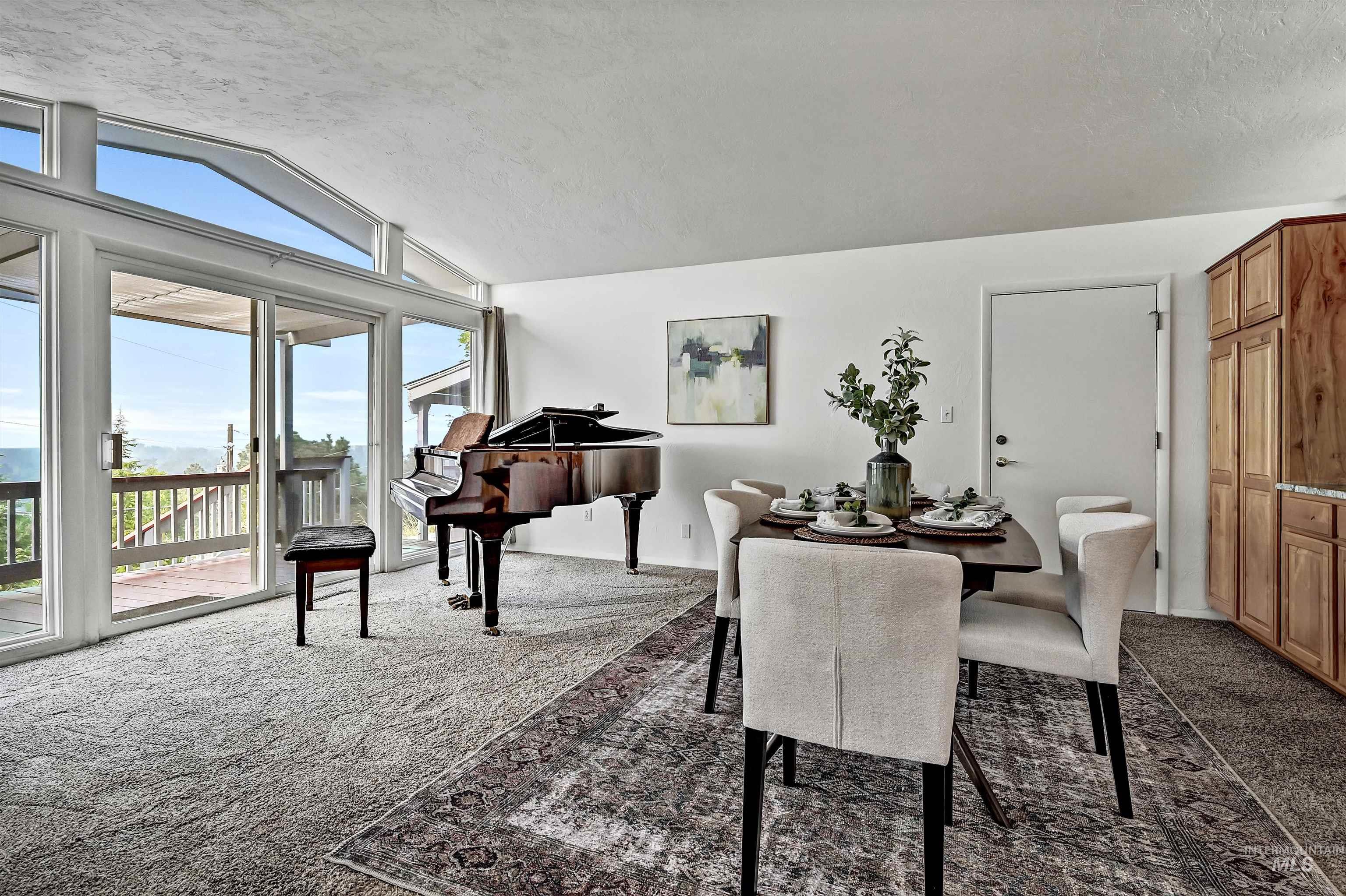 Dining space featuring dark carpet, lofted ceiling, and a textured ceiling