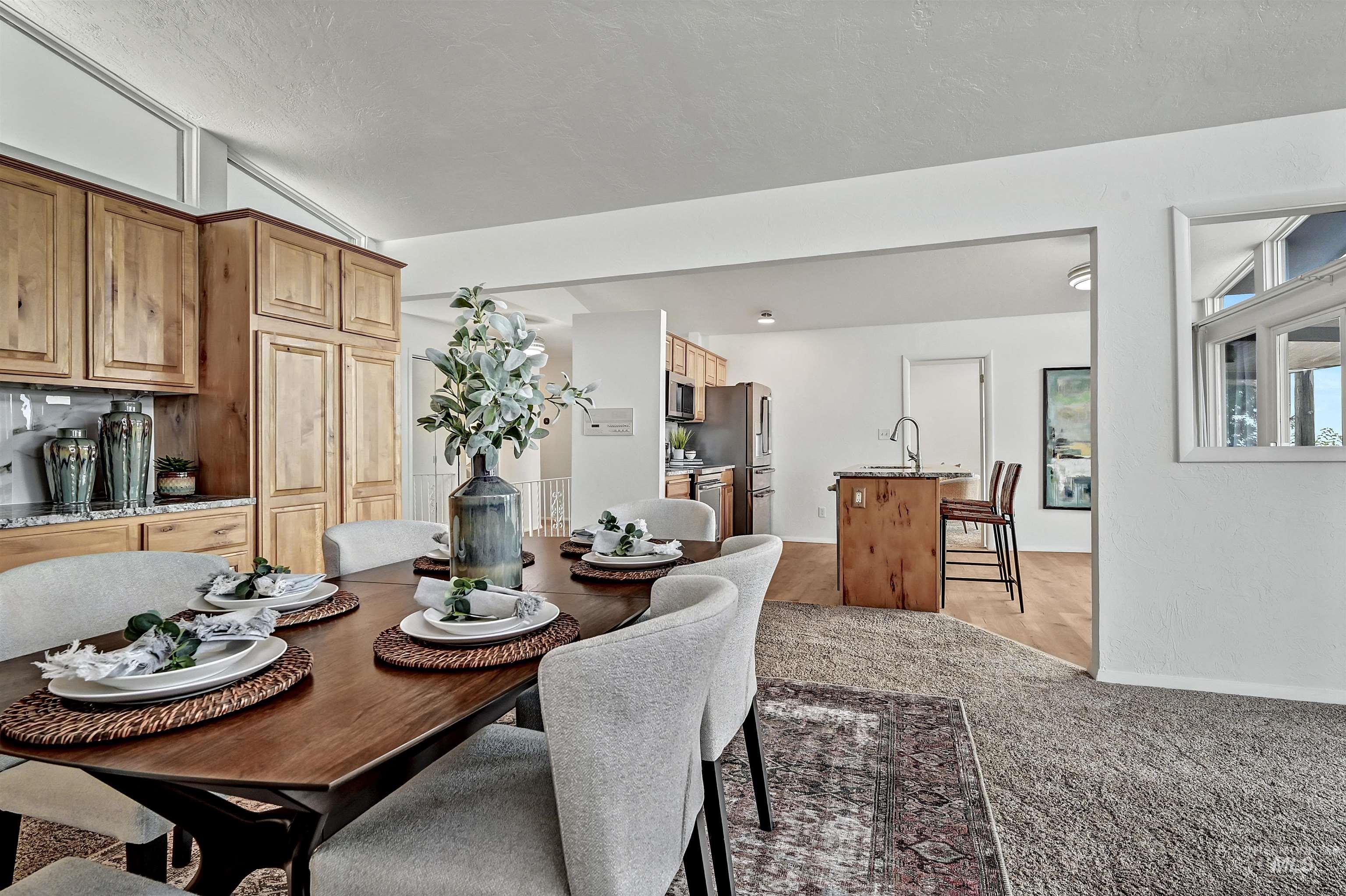 Dining space with light carpet and vaulted ceiling