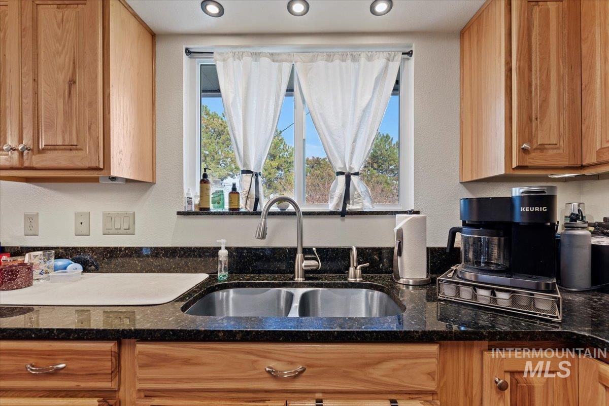 Kitchen featuring dark stone countertops and healthy amount of natural light