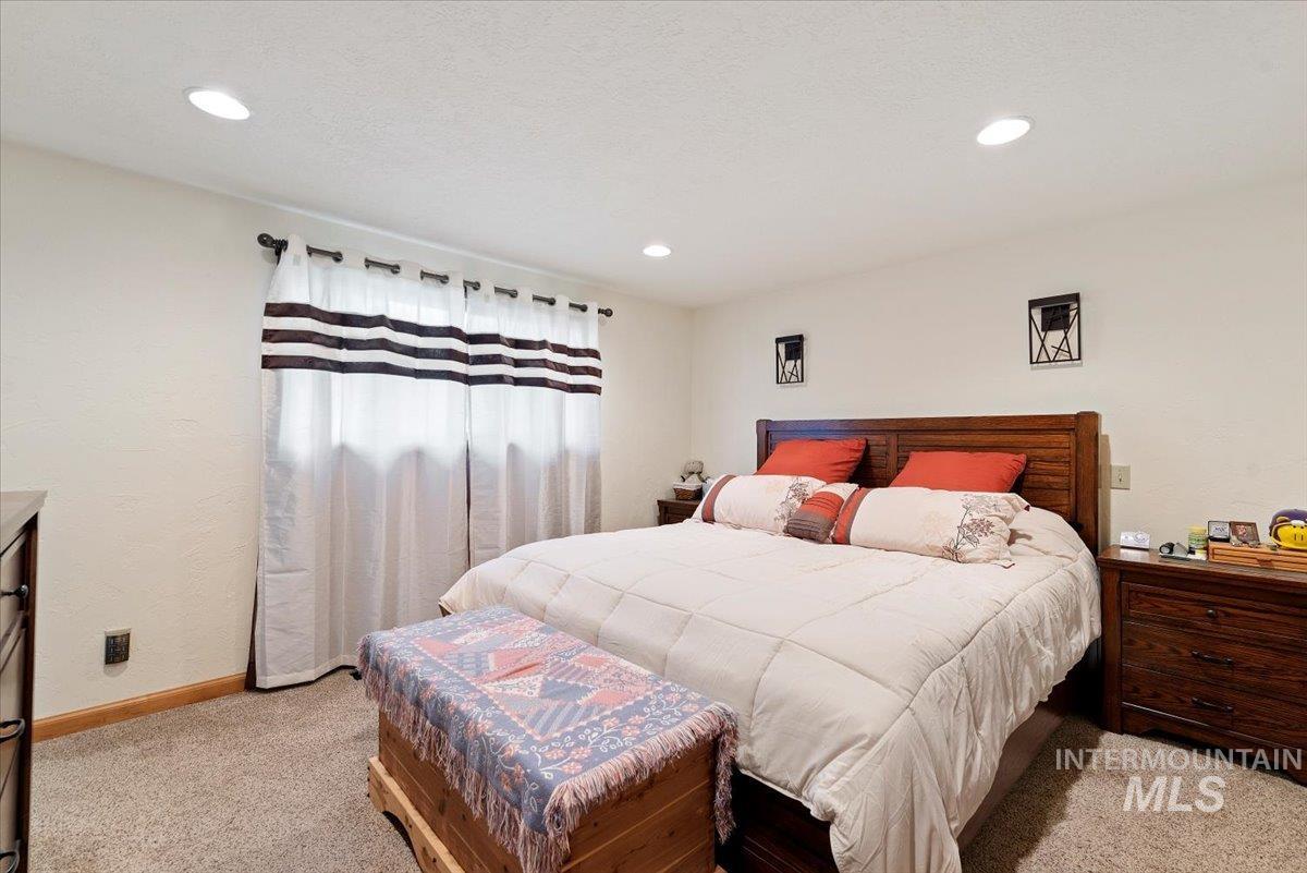 Bedroom with light colored carpet and recessed lighting