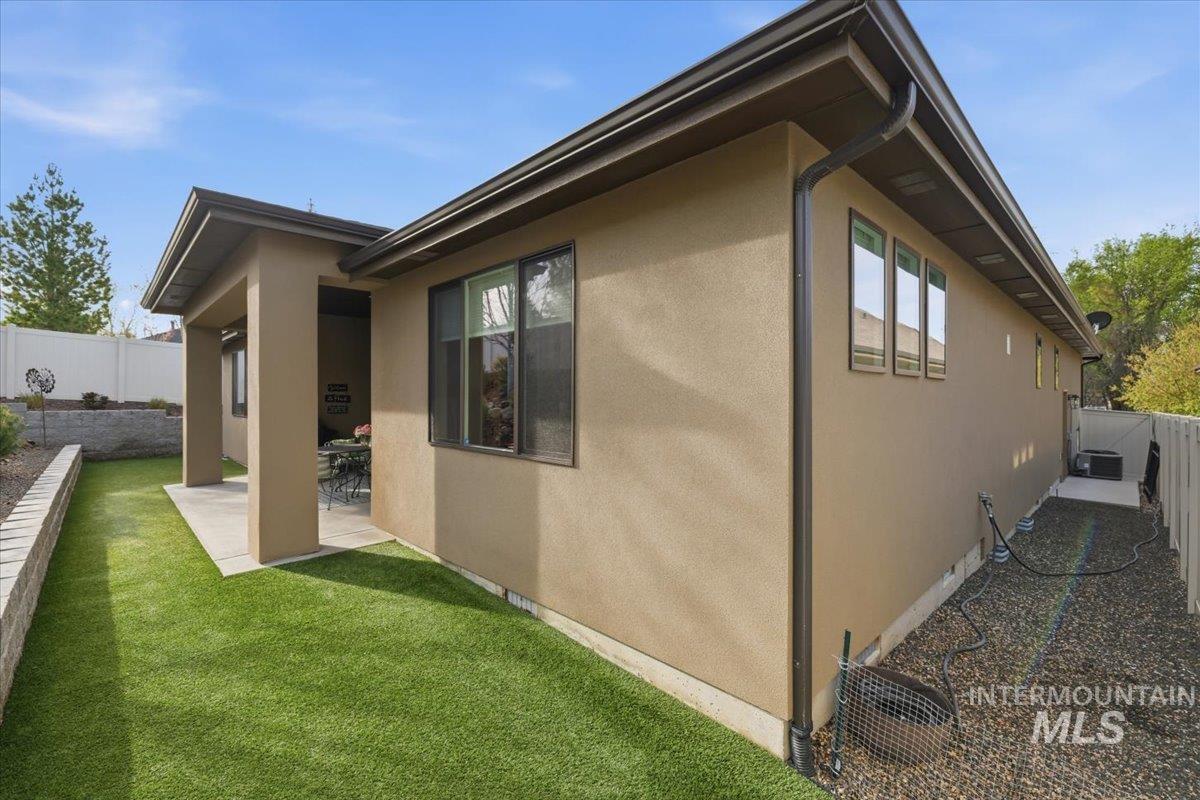 View of side of home featuring a fenced backyard, a patio, and stucco siding