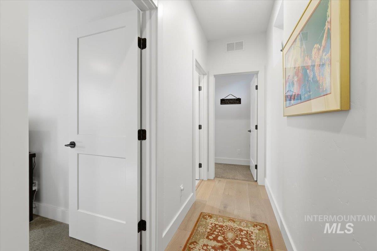 Hallway with baseboards and light wood-style flooring