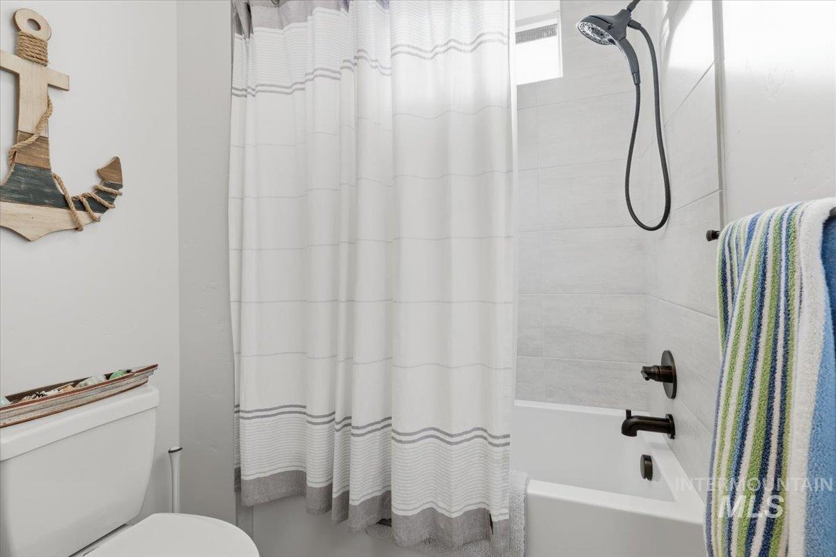 Full bath with shower / bath combination with curtain and toilet