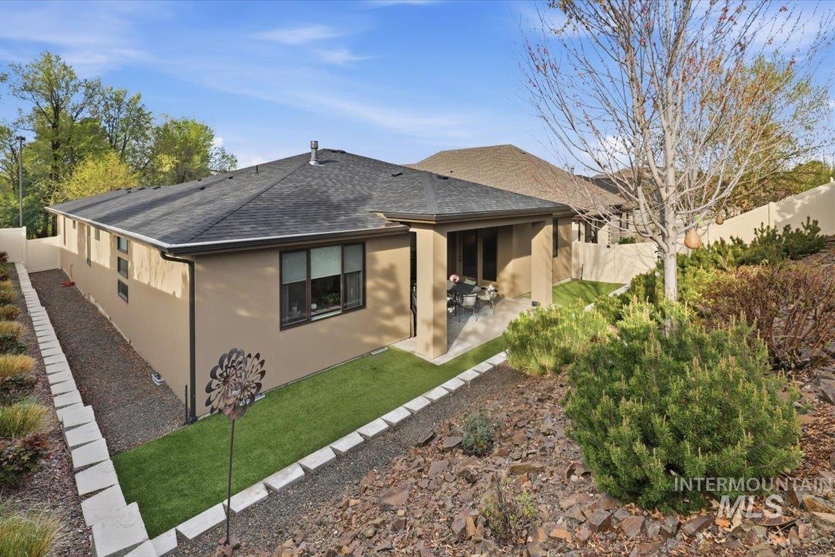 Back of house featuring a fenced backyard, a patio area, a shingled roof, and stucco siding