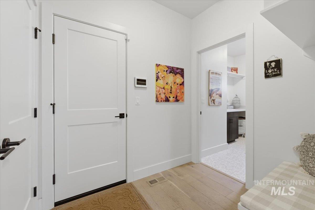 Entryway with light wood finished floors and baseboards