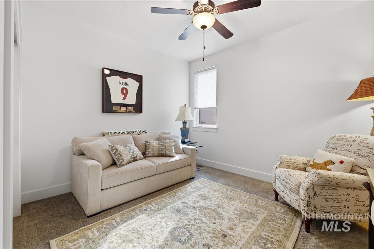 Living room featuring carpet flooring and ceiling fan