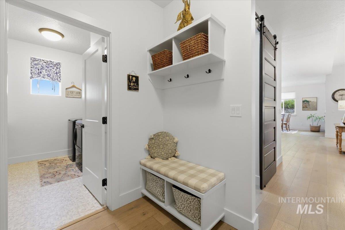 Mudroom with a barn door and light wood finished floors