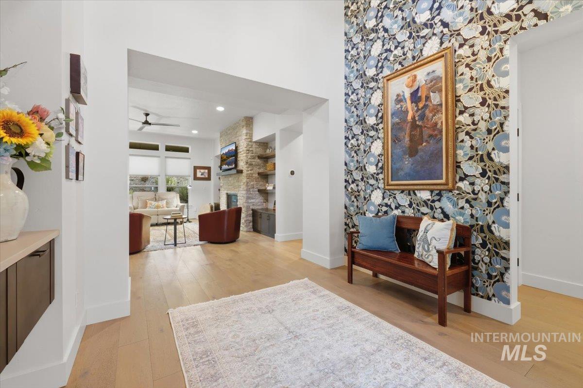 Hallway featuring light wood-style flooring and a high ceiling