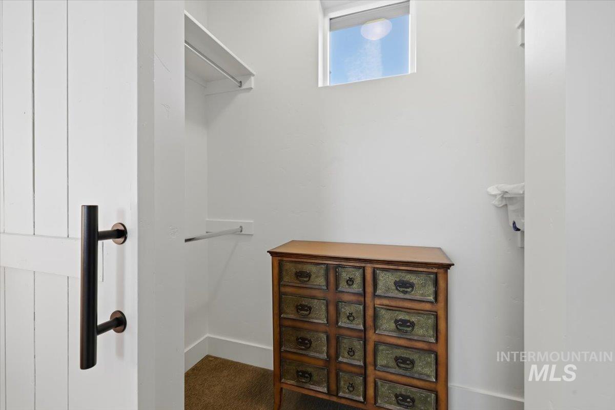 Walk in closet featuring dark colored carpet