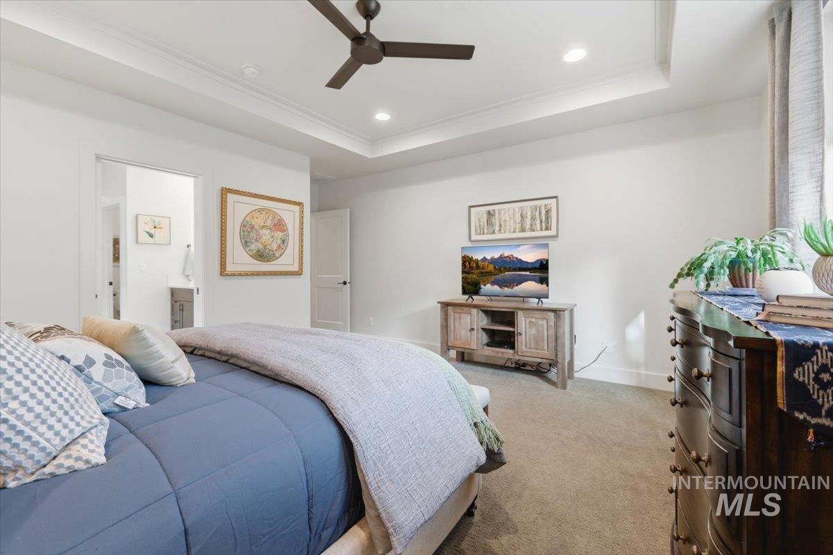 Bedroom featuring crown molding, carpet flooring, ceiling fan, recessed lighting, and a tray ceiling