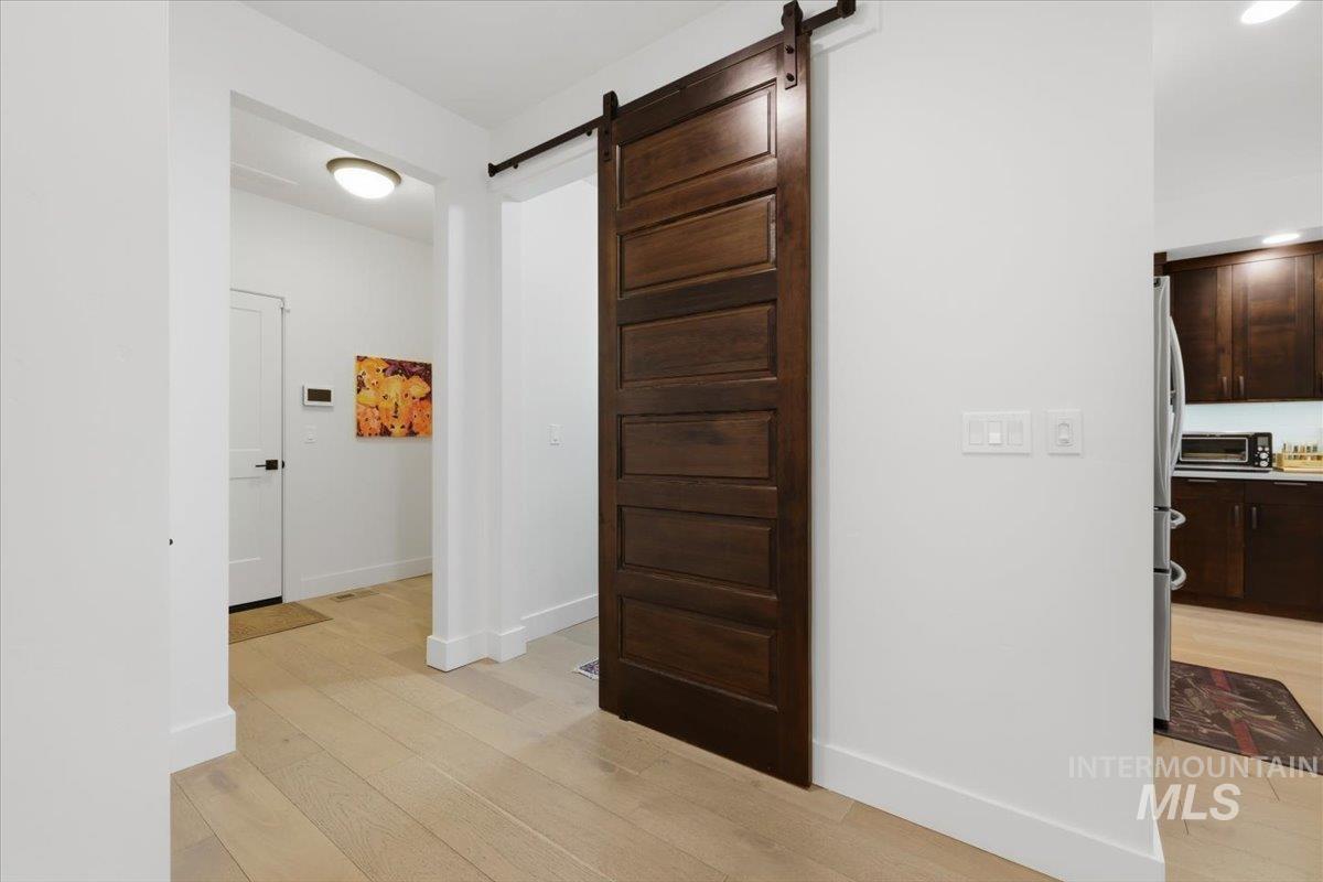 Hallway featuring a barn door and light wood-style floors