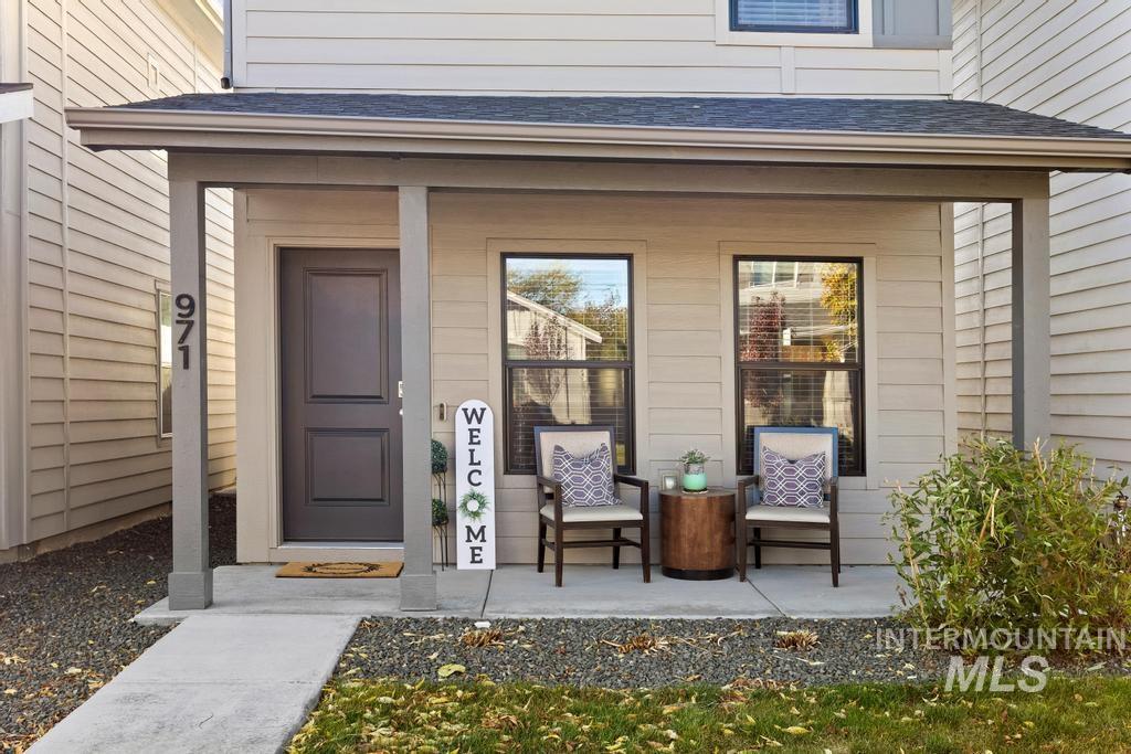 Doorway to property with a shingled roof and a porch