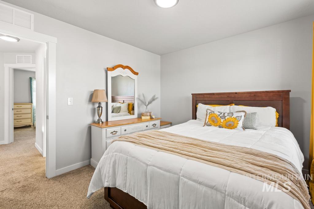 Bedroom featuring light colored carpet and baseboards