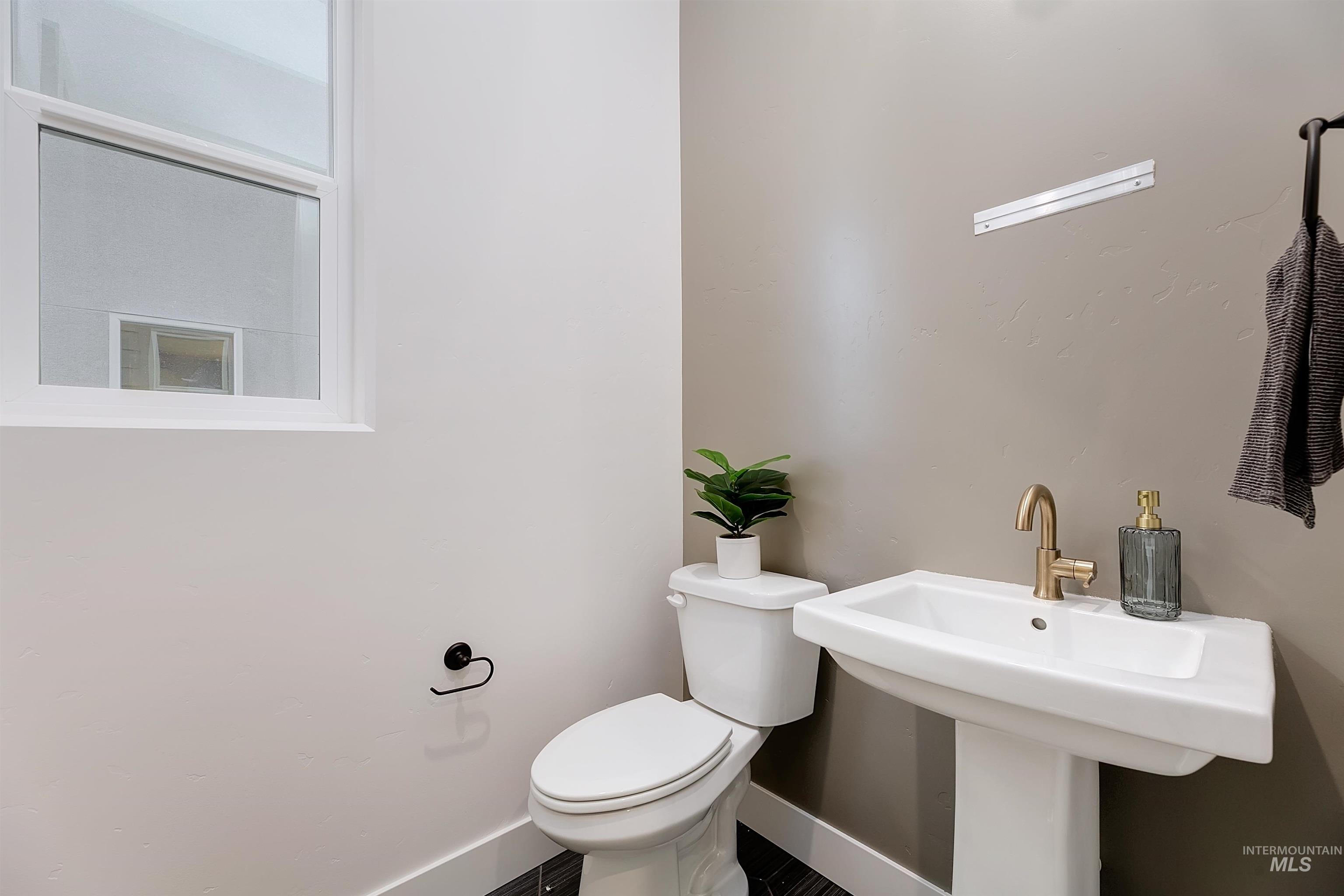 Half bath featuring toilet and baseboards