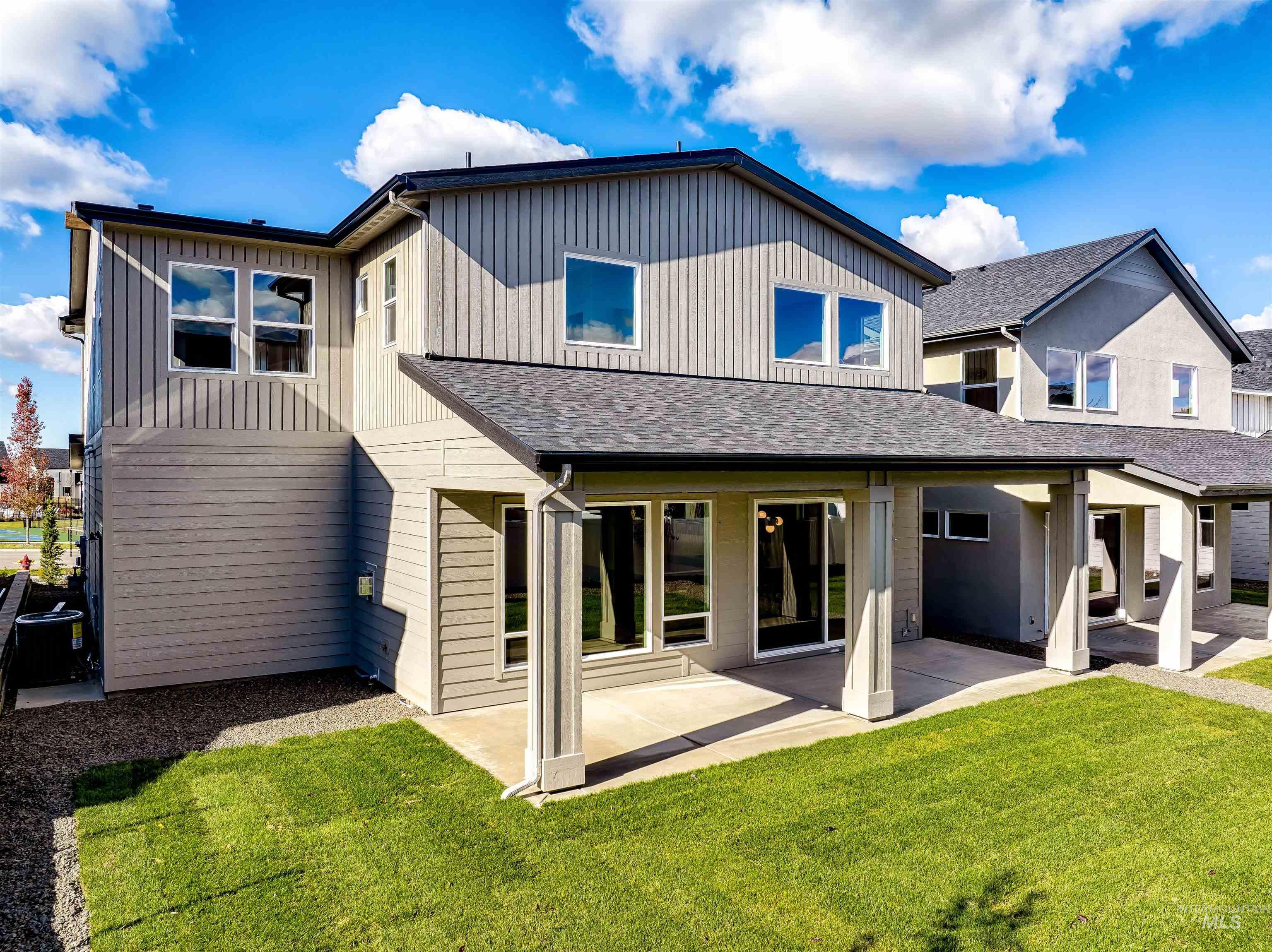 Back of house featuring a patio, a yard, and roof with shingles