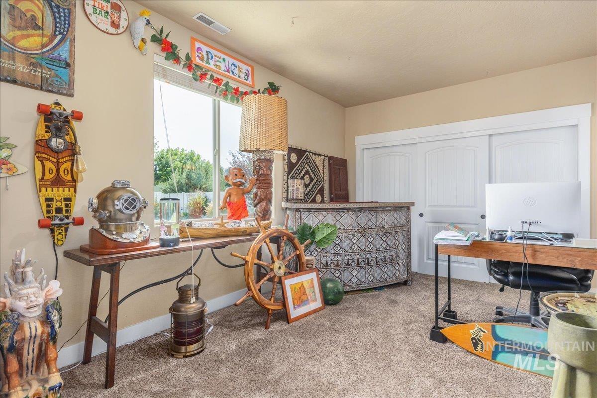 Carpeted home office featuring baseboards