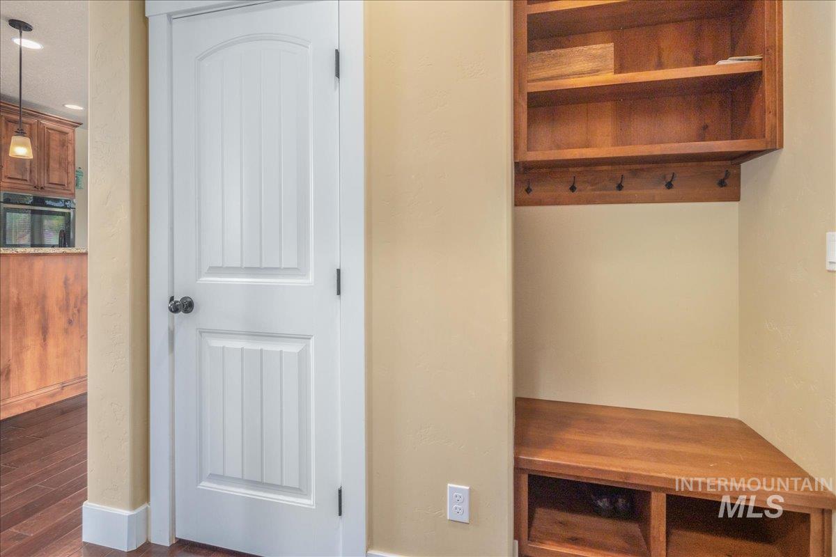 Mudroom with dark wood-style flooring and baseboards