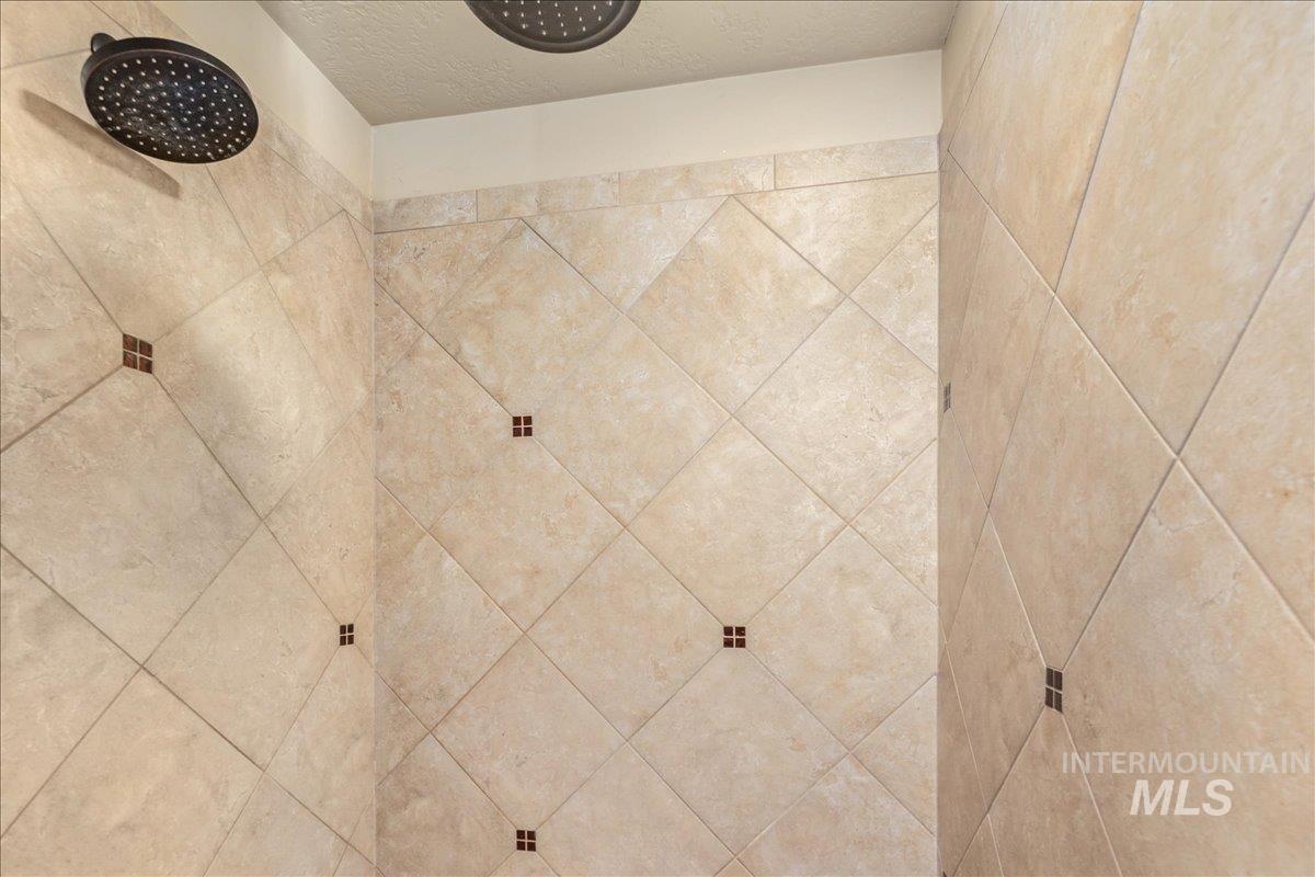Bathroom view of tiled shower and a textured ceiling