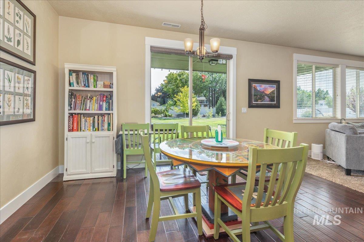 Dining room featuring a chandelier and dark wood-style floors