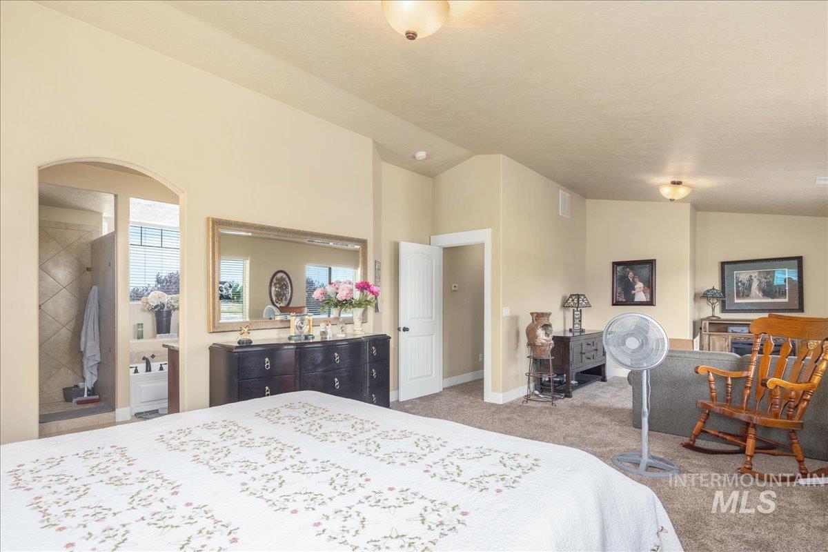 Carpeted bedroom with lofted ceiling and baseboards