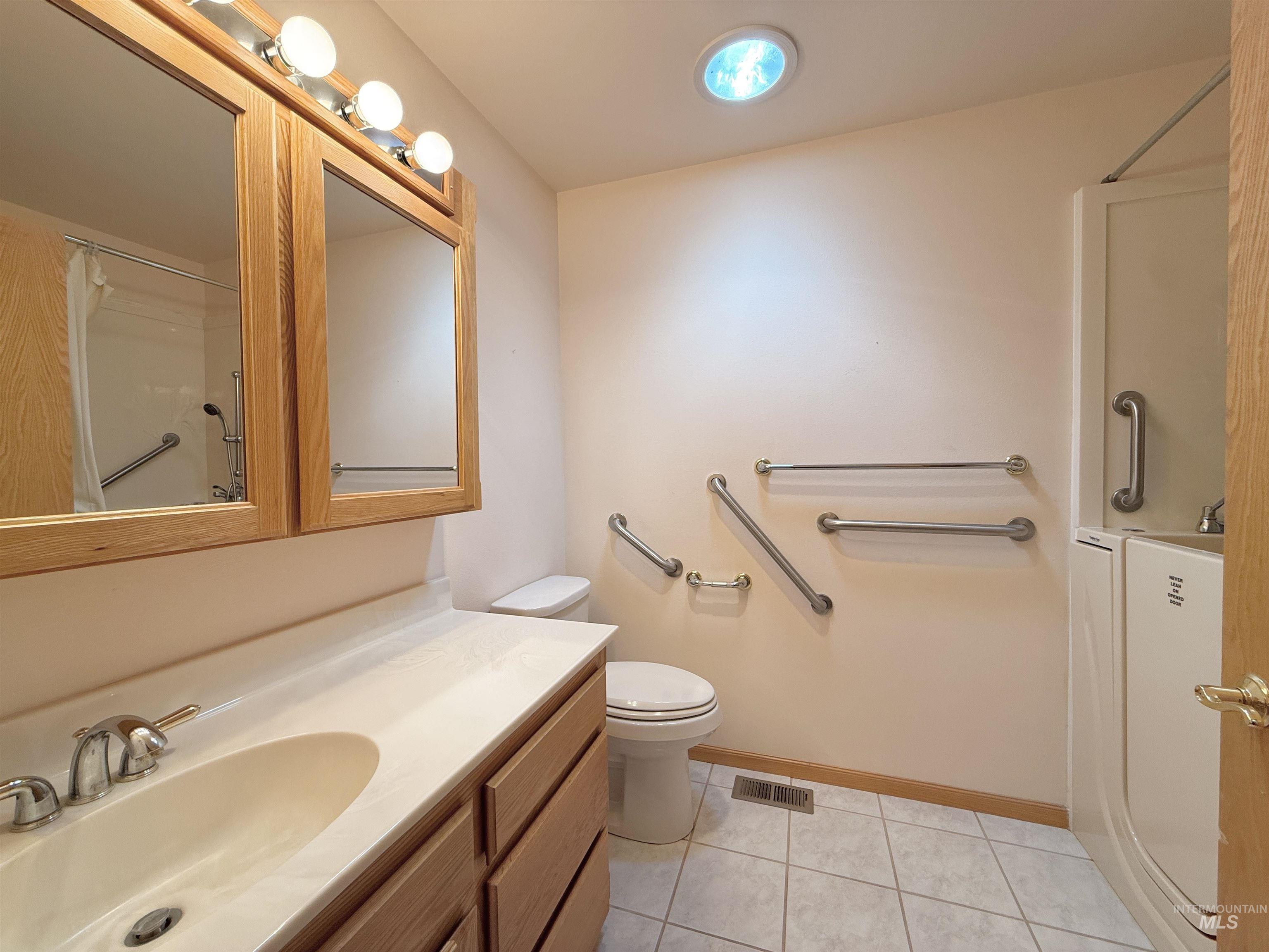 Bathroom featuring tile patterned floors, vanity, and a shower