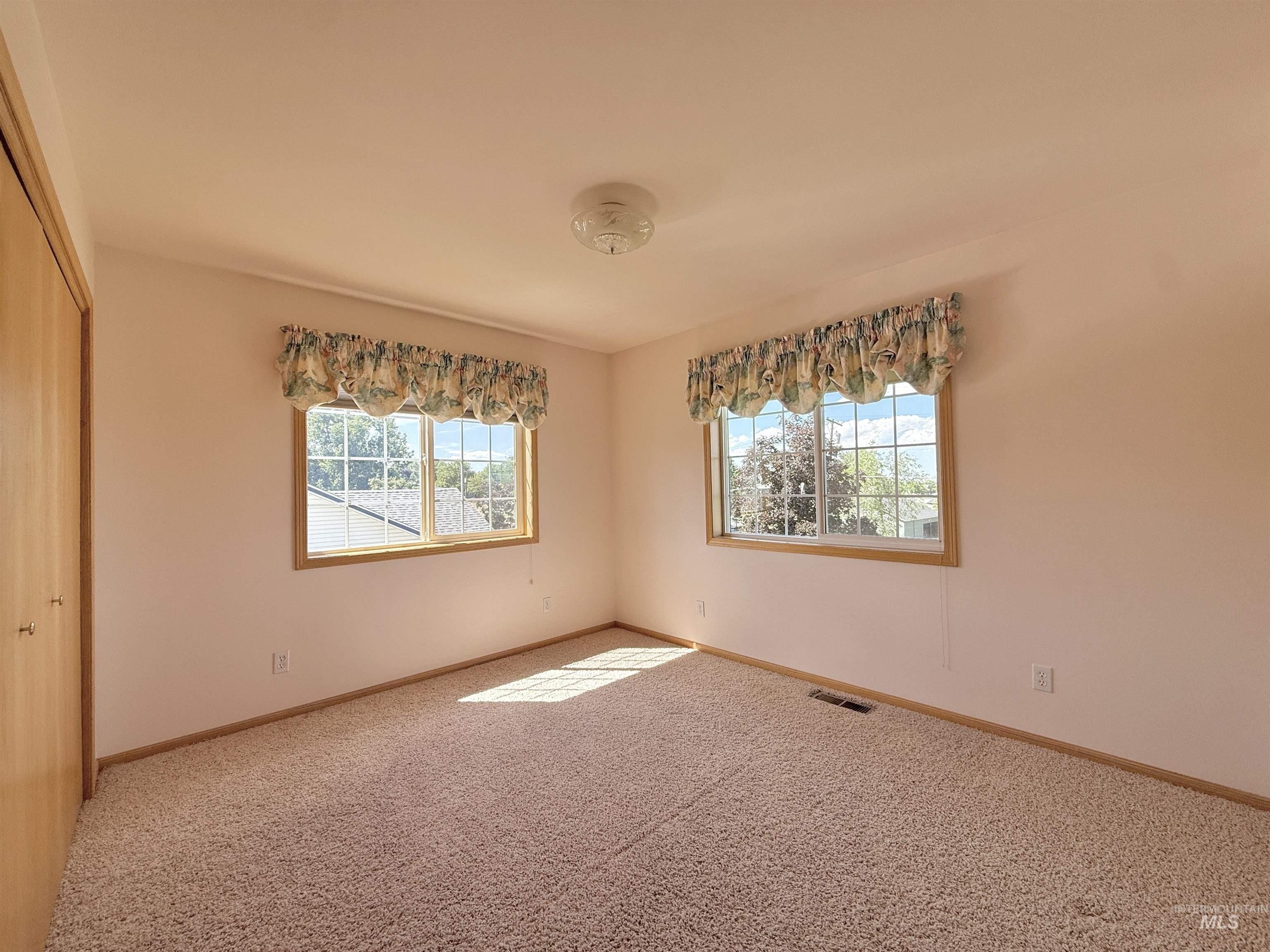 Unfurnished room with carpet and baseboards