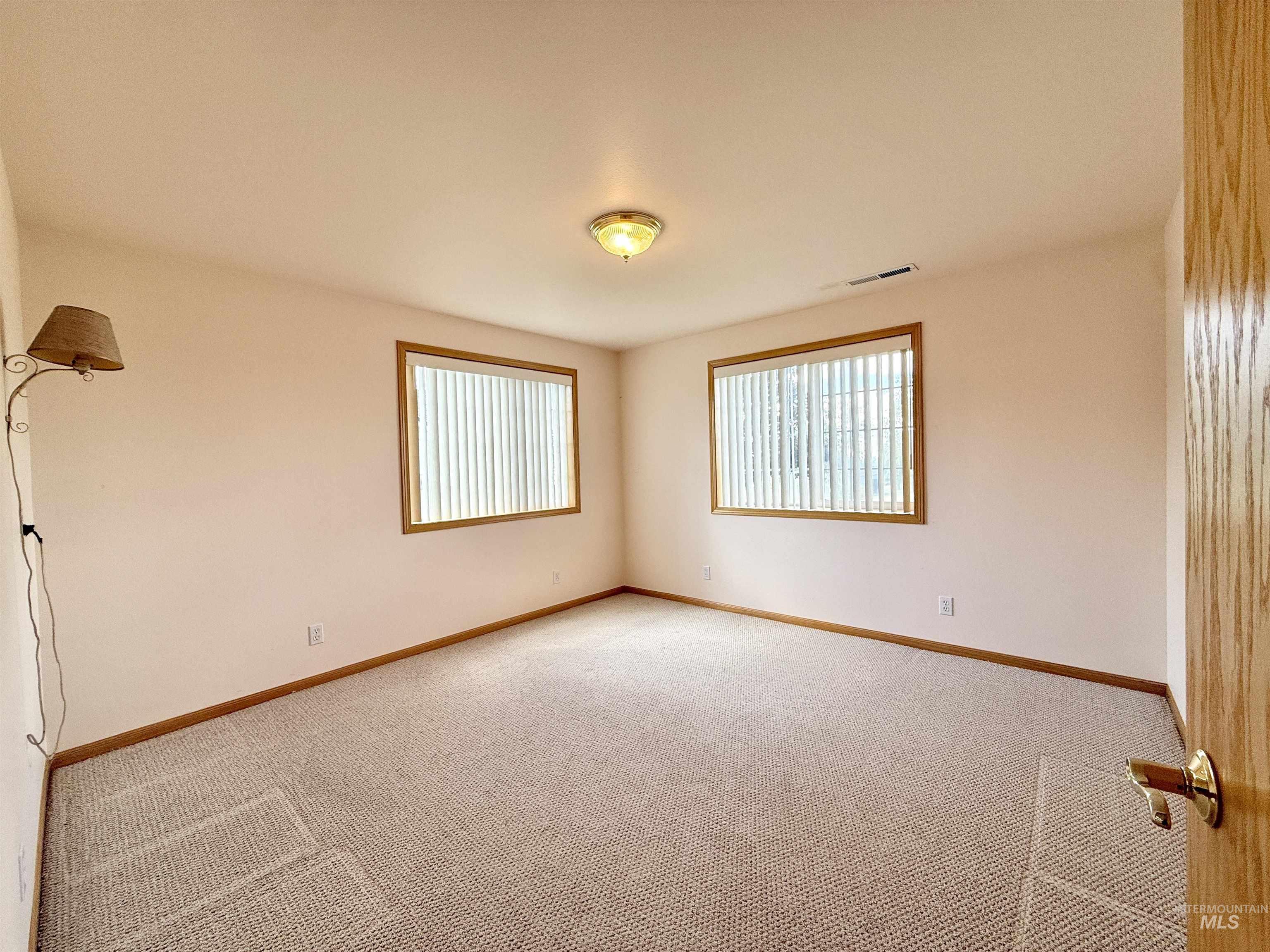Unfurnished room with plenty of natural light and light colored carpet